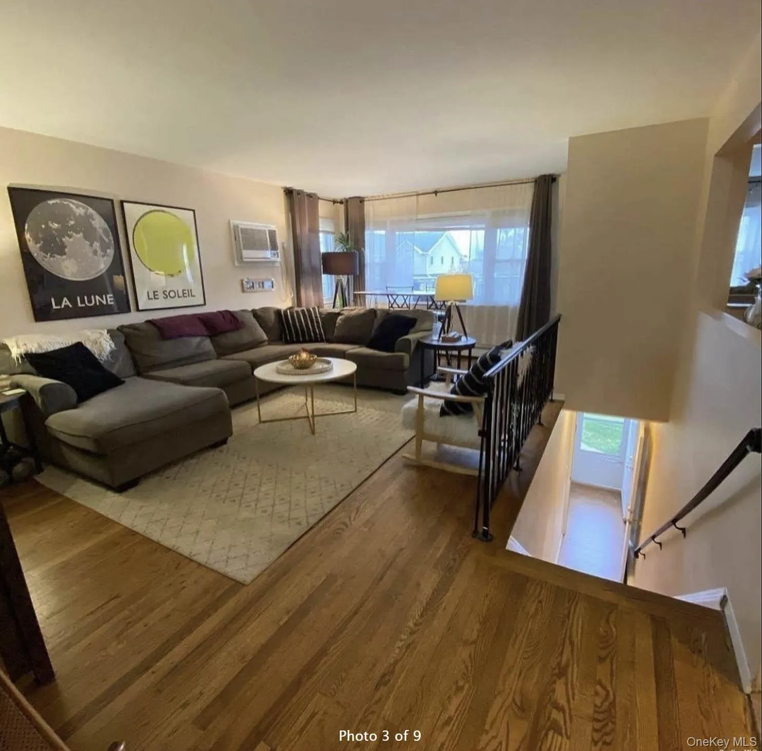 Living room with wood finished floors and a wall mounted air conditioner Living room with wood finished floors and a wall mounted air conditioner