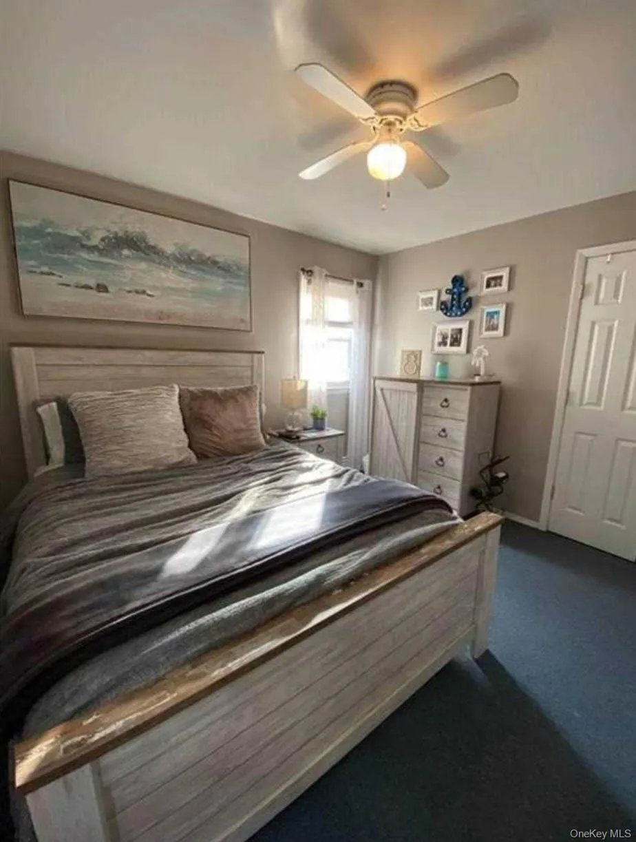 Bedroom featuring dark carpet and ceiling fan Bedroom featuring dark carpet and ceiling fan