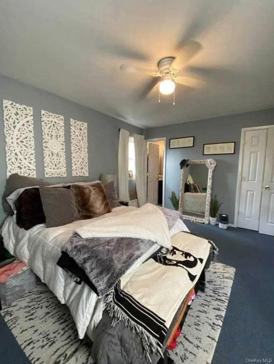 Bedroom with a ceiling fan and dark colored carpet Bedroom with a ceiling fan and dark colored carpet