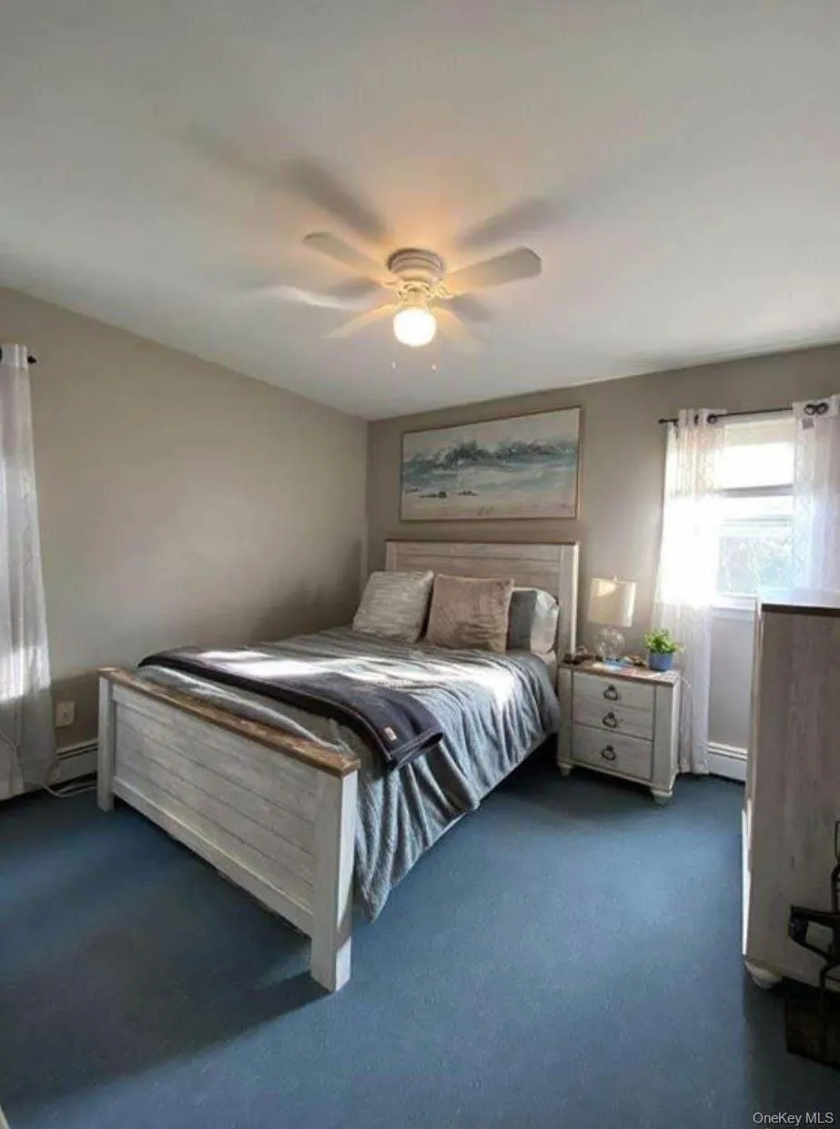 Carpeted bedroom featuring a ceiling fan Carpeted bedroom featuring a ceiling fan