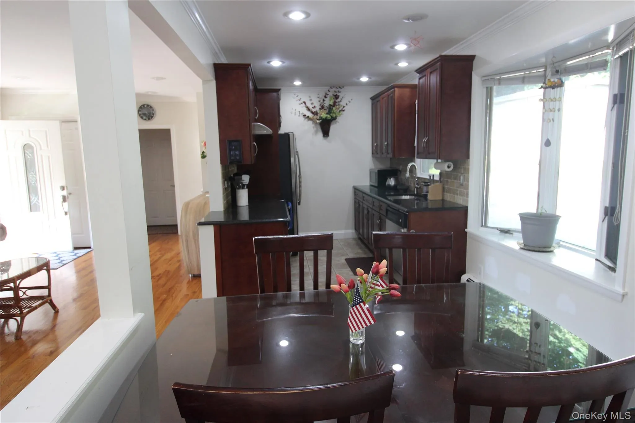 Compact kitchen featuring dark wood cabinetry, recessed lighting, and a bay window Compact kitchen featuring dark wood cabinetry, recessed lighting, and a bay window