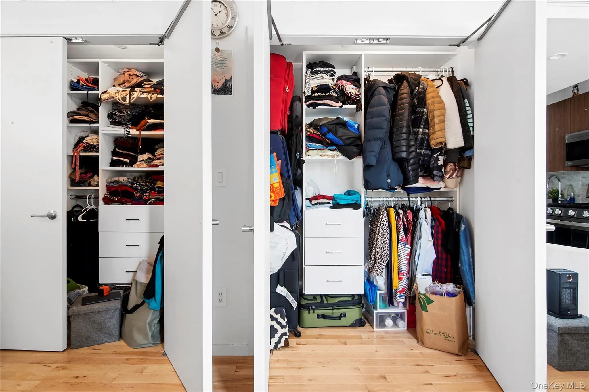 Custom closet organization system featuring white shelving, drawers with integrated pulls, and hanging rods Custom closet organization system featuring white shelving, drawers with integrated pulls, and hanging rods