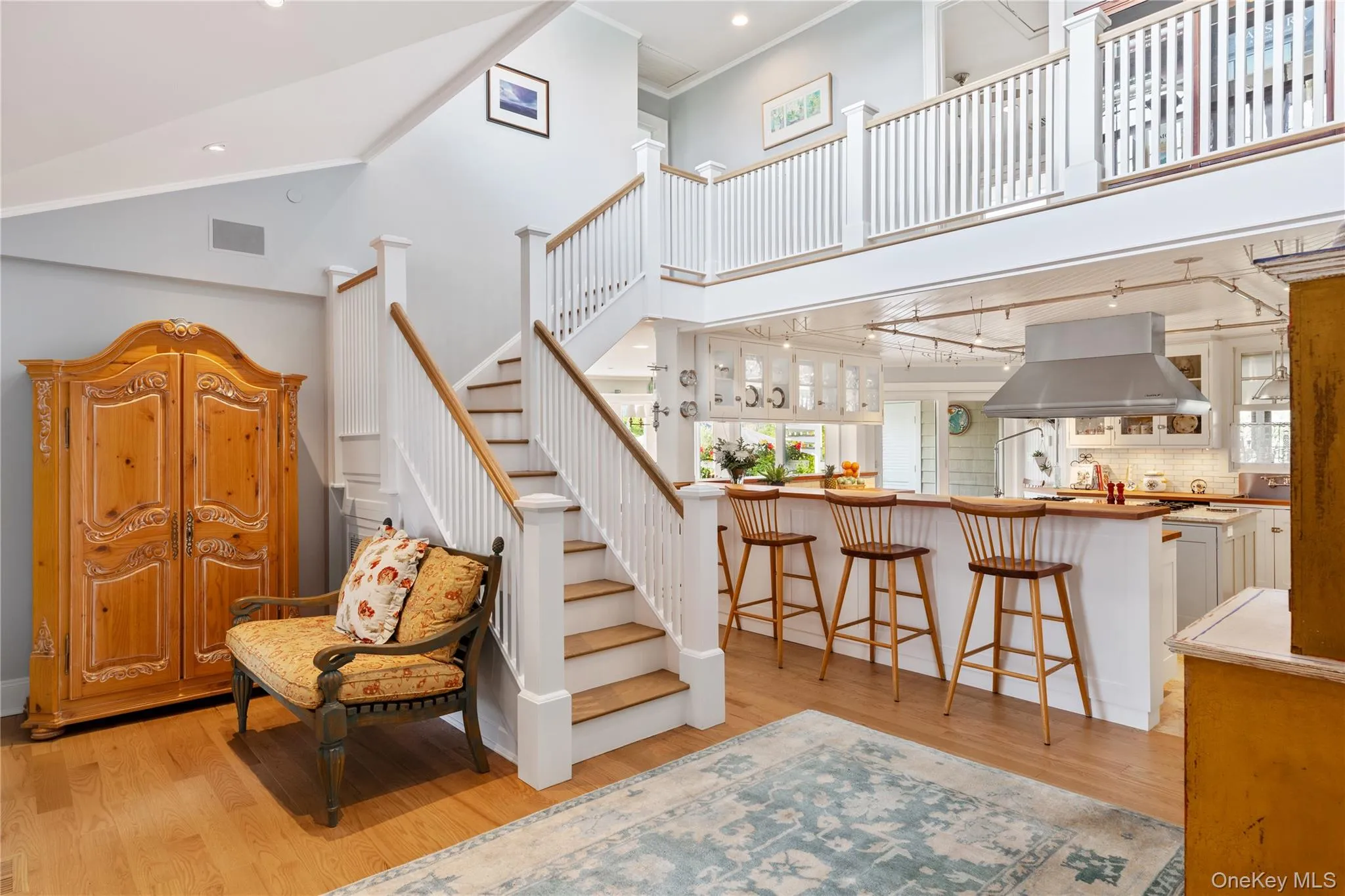 Stairs with recessed lighting, ornamental molding, wood finished floors, and high vaulted ceiling Stairs with recessed lighting, ornamental molding, wood finished floors, and high vaulted ceiling