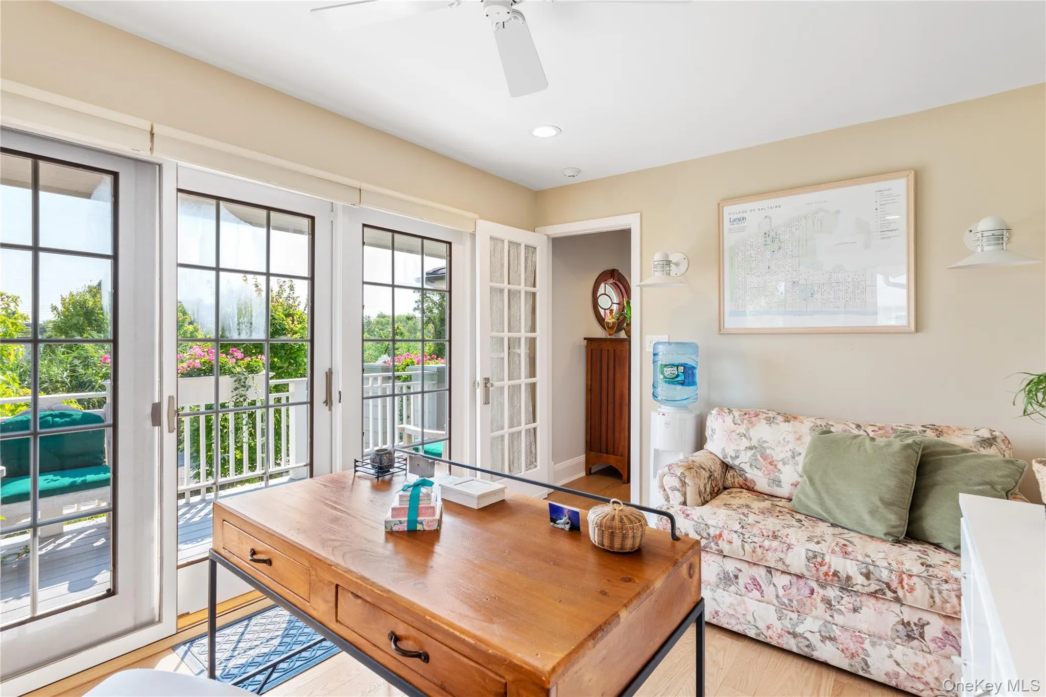 Home office featuring sliding glass doors, ceiling fan, and wood finished floors Home office featuring sliding glass doors, ceiling fan, and wood finished floors