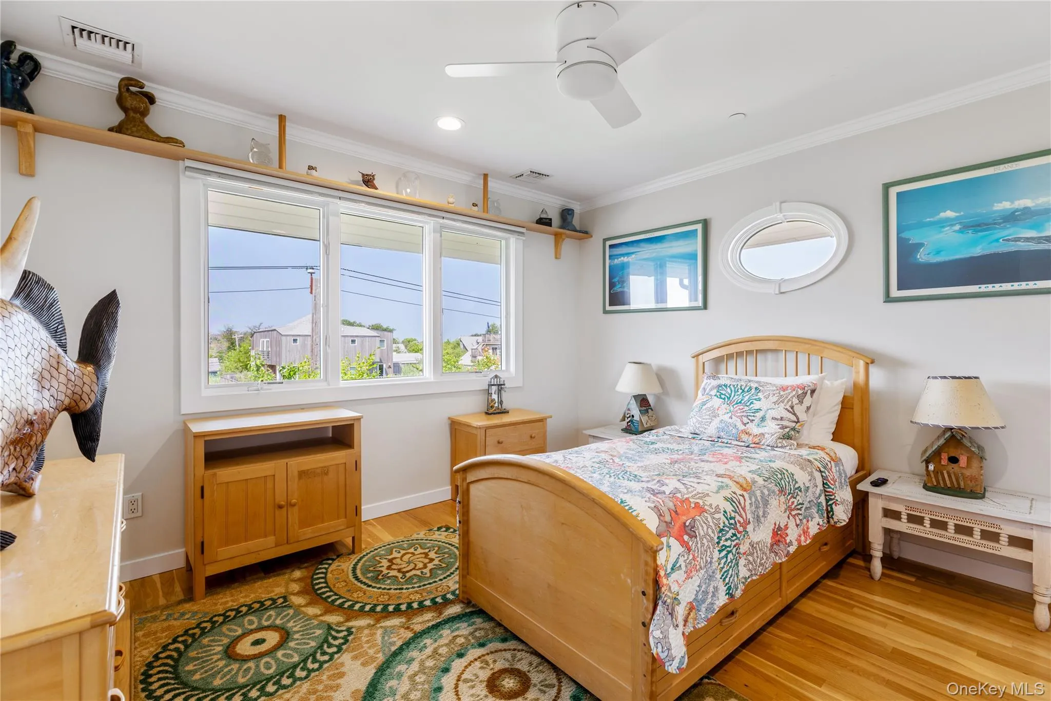 Bedroom 4 featuring a raised shelf, a fixed oval shaped window and plenty of large windows facing the lighthouse and a ceiling fan with light Bedroom 4 featuring a raised shelf, a fixed oval shaped window and plenty of large windows facing the lighthouse and a ceiling fan with light