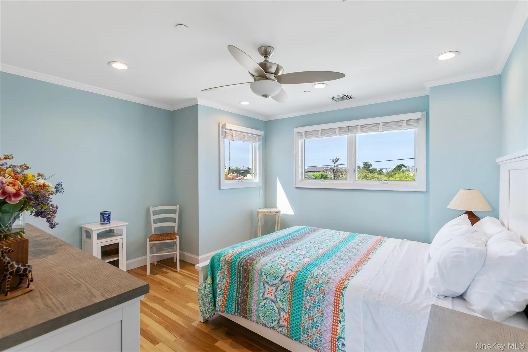 Bedroom 5 featuring natural light, wood flooring, and a ceiling fan with light Bedroom 5 featuring natural light, wood flooring, and a ceiling fan with light