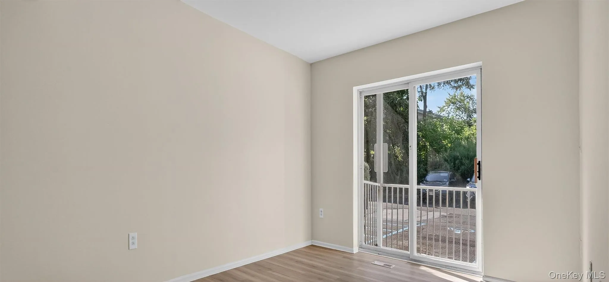 Unfurnished room with light wood finished floors and baseboards Unfurnished room with light wood finished floors and baseboards