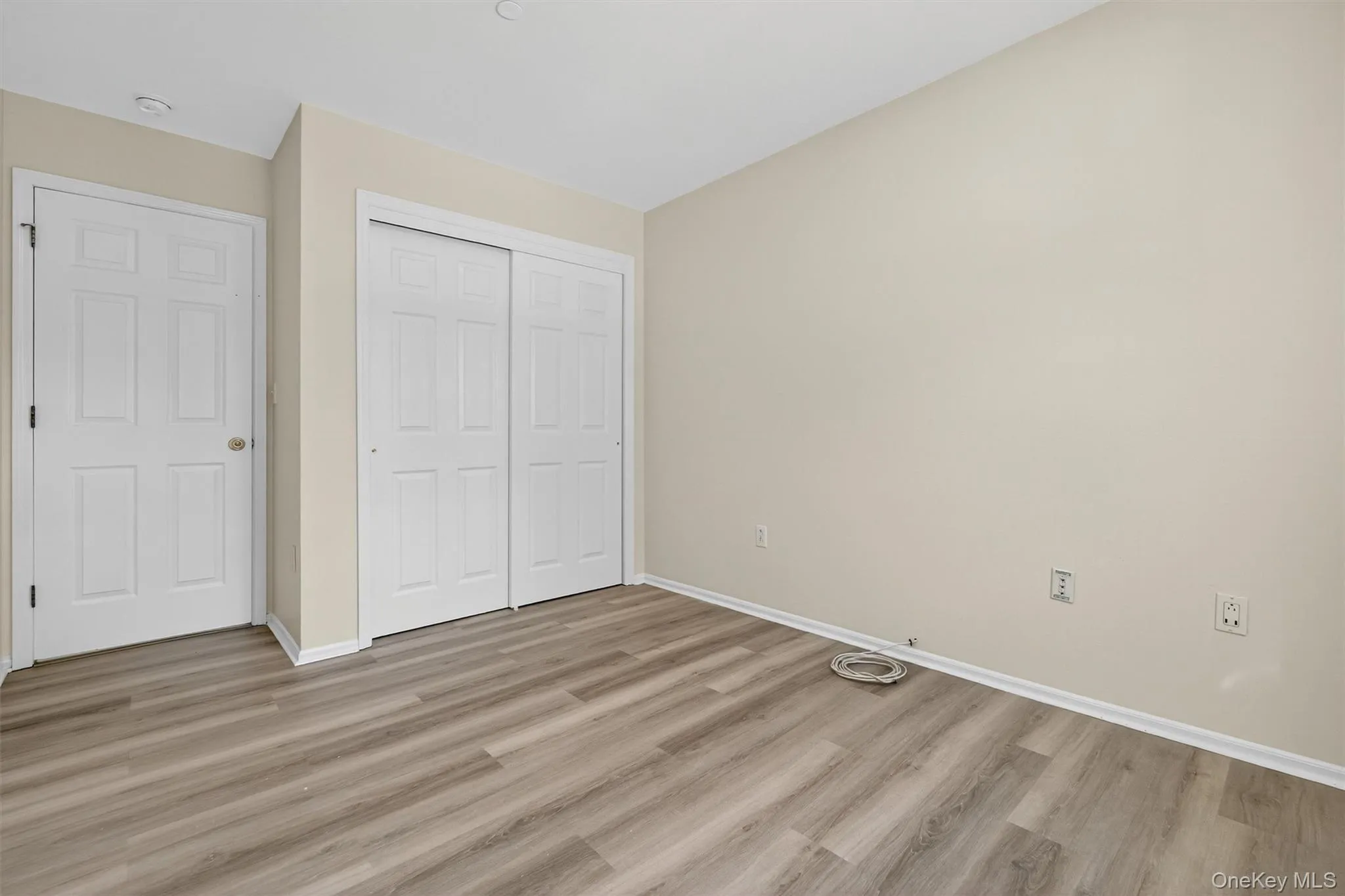 Unfurnished bedroom with light wood finished floors and a closet Unfurnished bedroom with light wood finished floors and a closet