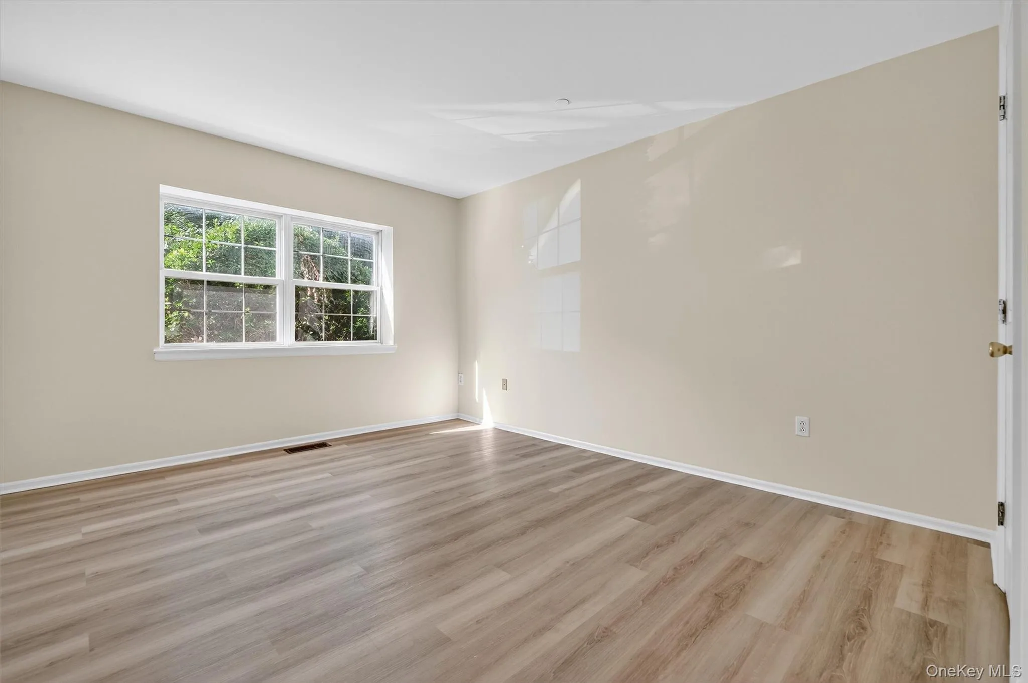 Empty room with light wood-type flooring and baseboards Empty room with light wood-type flooring and baseboards
