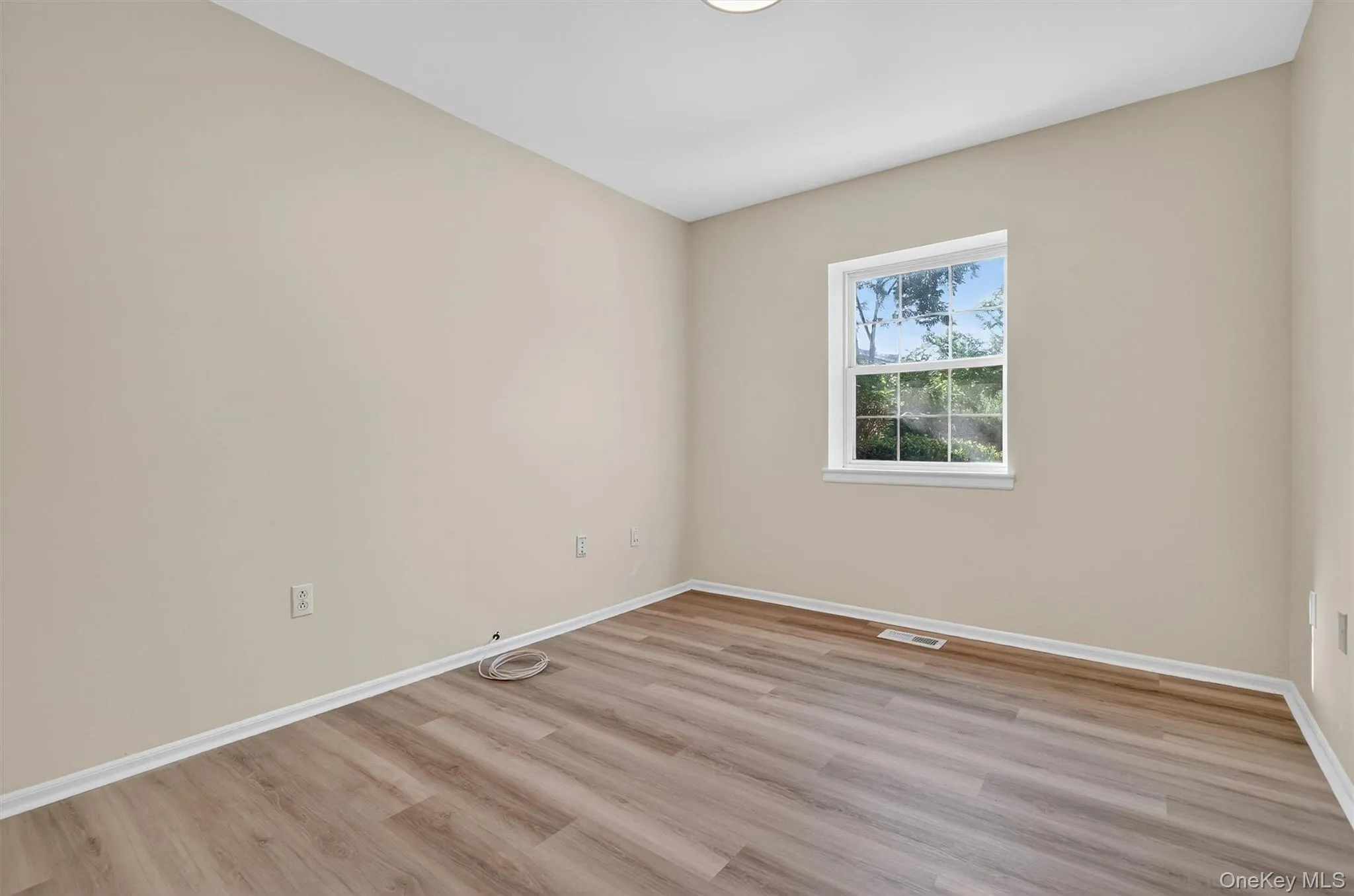 Spare room with baseboards and light wood-style floors Spare room with baseboards and light wood-style floors