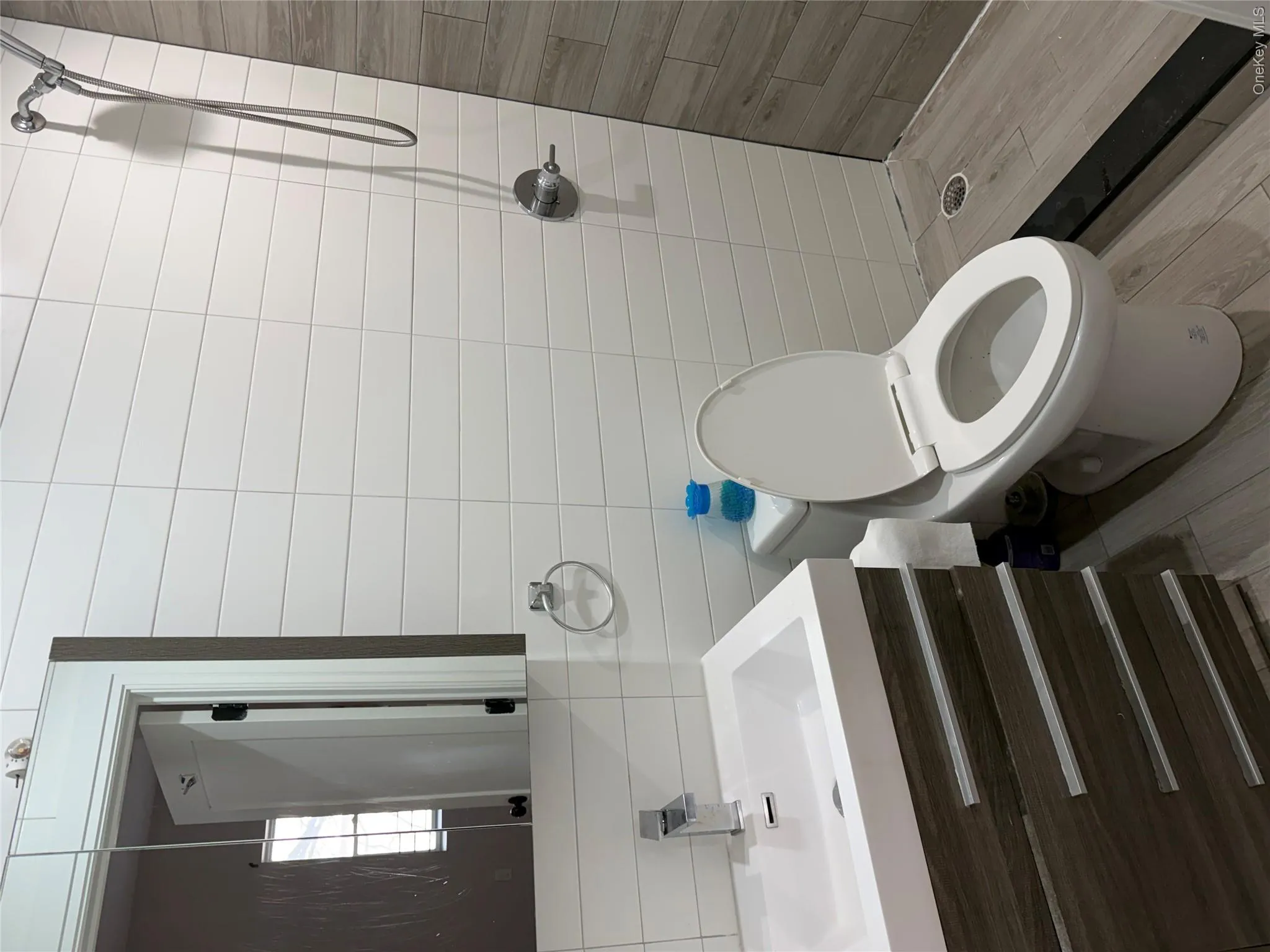 Bathroom featuring a wood-finish vanity with an integrated white sink and a chrome faucet Bathroom featuring a wood-finish vanity with an integrated white sink and a chrome faucet