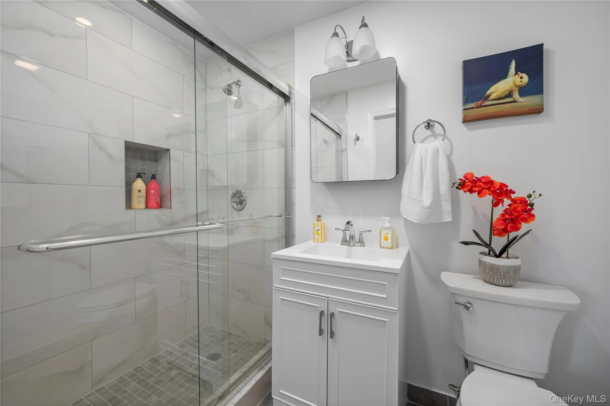 Modern bathroom featuring a shower with a sliding glass door and tiled walls, a vanity with cabinet storage Modern bathroom featuring a shower with a sliding glass door and tiled walls, a vanity with cabinet storage