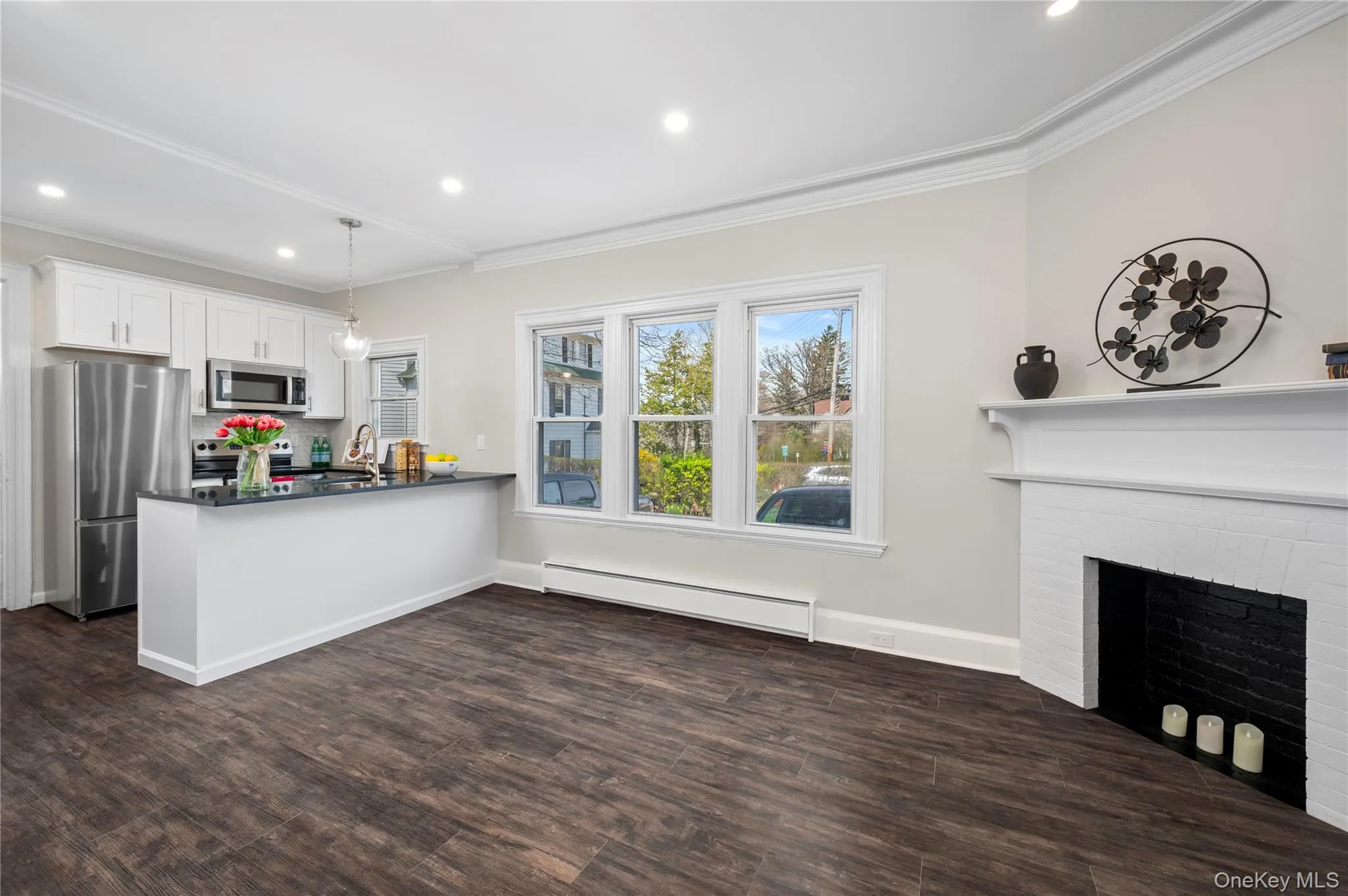 Bright and inviting open concept living space featuring dark wood-style flooring Bright and inviting open concept living space featuring dark wood-style flooring
