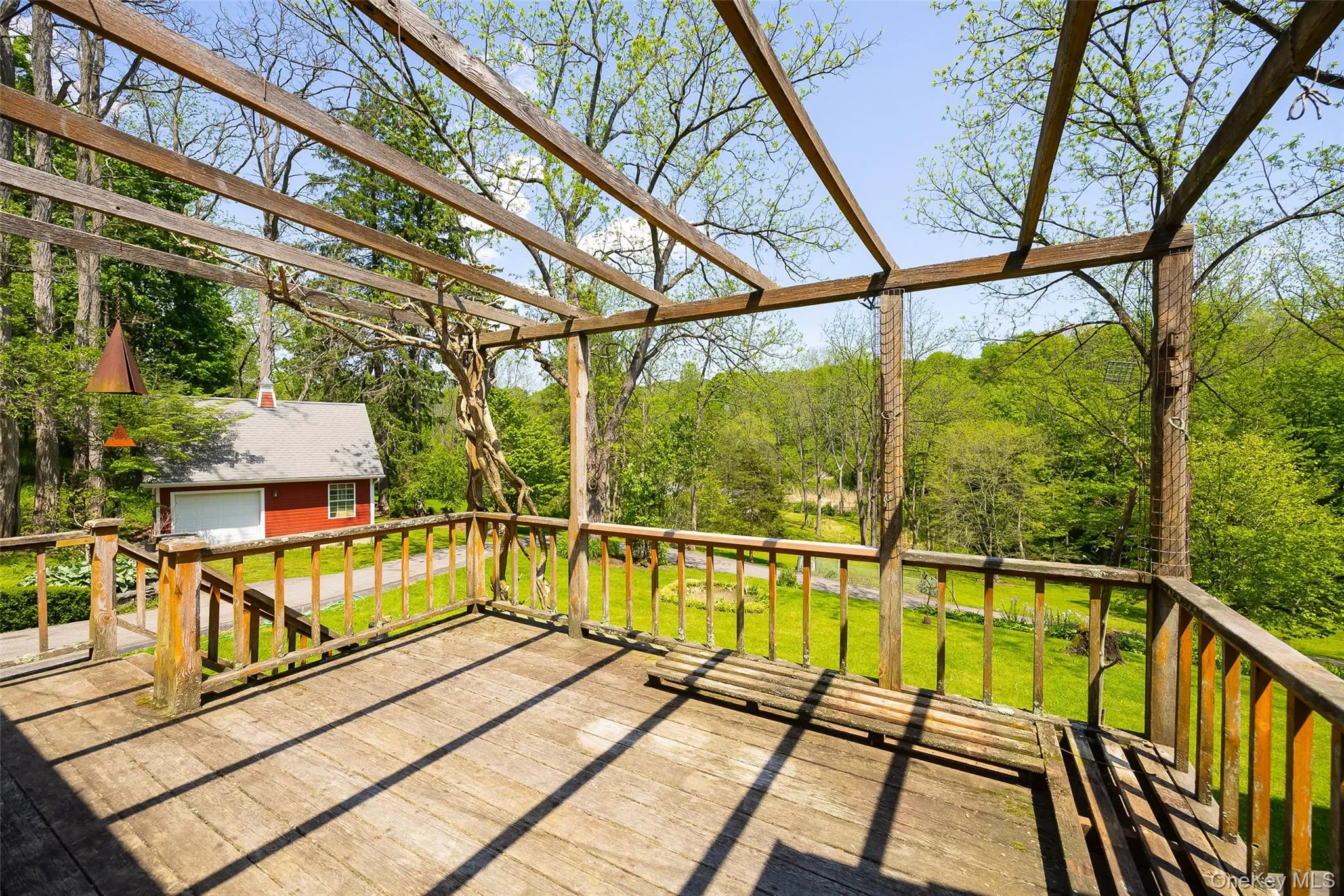 Expansive outdoor deck featuring a pergola with ruby orange trumpet vine Expansive outdoor deck featuring a pergola with ruby orange trumpet vine