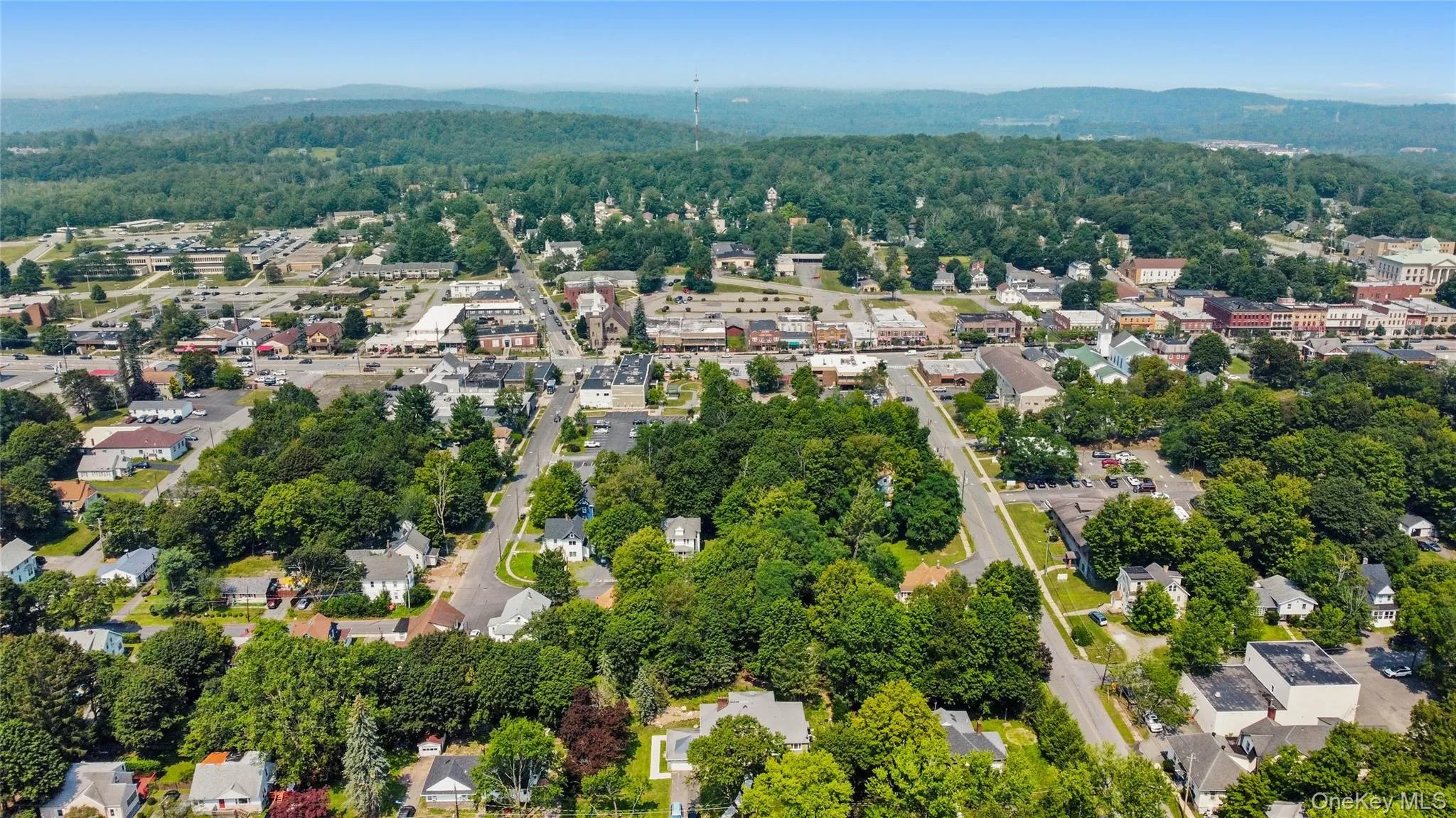 Aerial view of property and surrounding area featuring nearby suburban area and mountains Aerial view of property and surrounding area featuring nearby suburban area and mountains