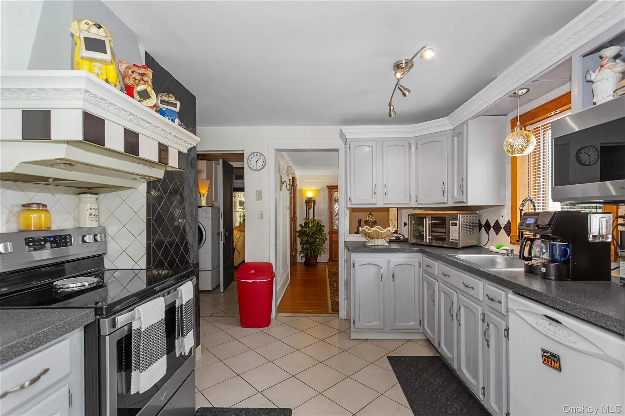Kitchen featuring, dark countertops, backsplash, light tile patterned flooring, and healthy amount of natural light Kitchen featuring, dark countertops, backsplash, light tile patterned flooring, and healthy amount of natural light