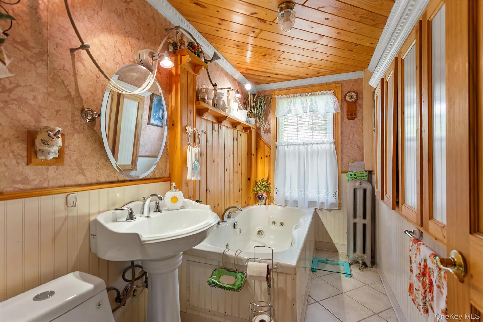 Bathroom featuring wallpapered walls, a whirlpool tub, wooden ceiling, a wainscoted wall, and wooden walls Bathroom featuring wallpapered walls, a whirlpool tub, wooden ceiling, a wainscoted wall, and wooden walls