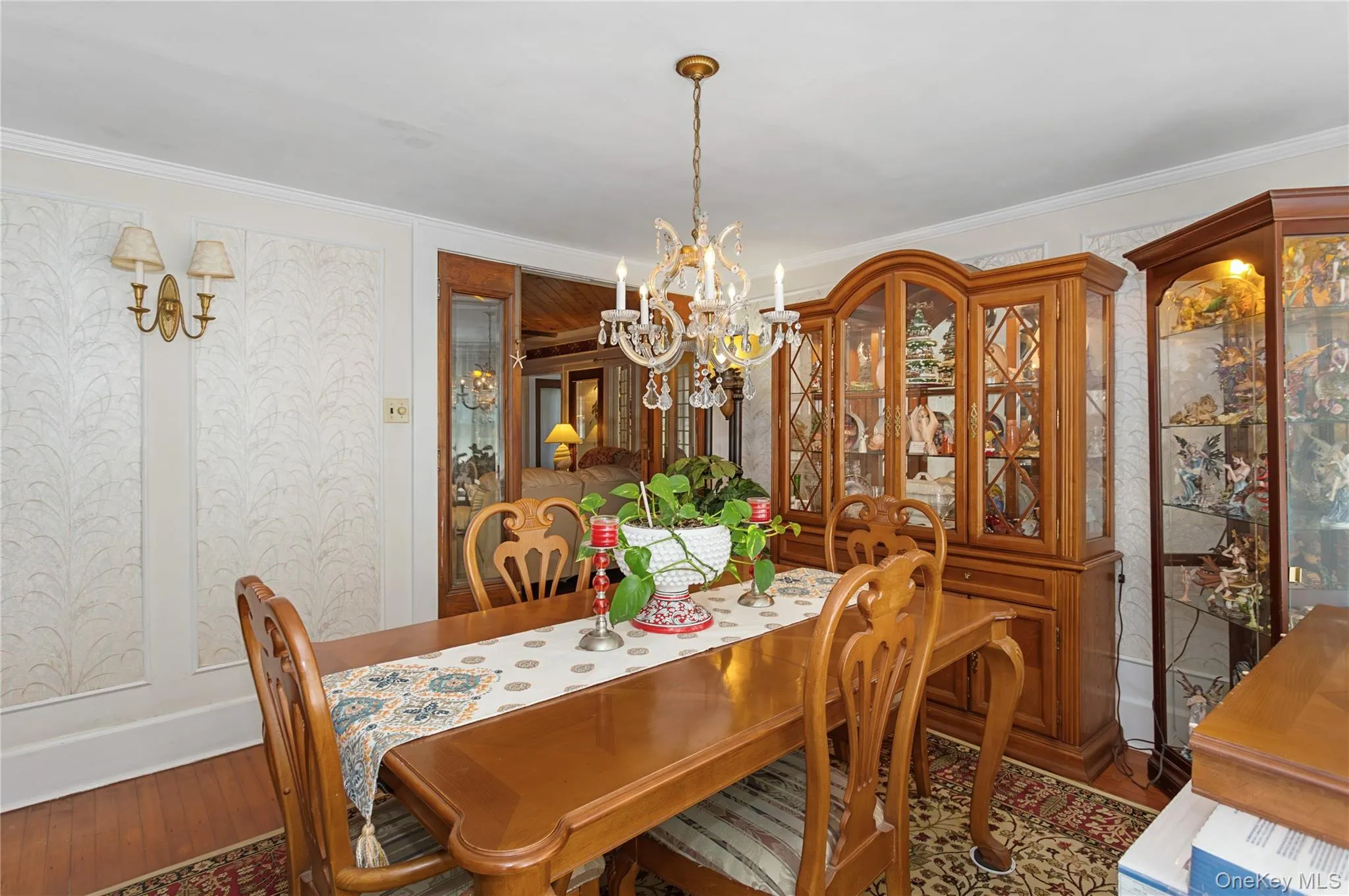Dining area featuring a chandelier, ornamental molding, and wood finished floors Dining area featuring a chandelier, ornamental molding, and wood finished floors