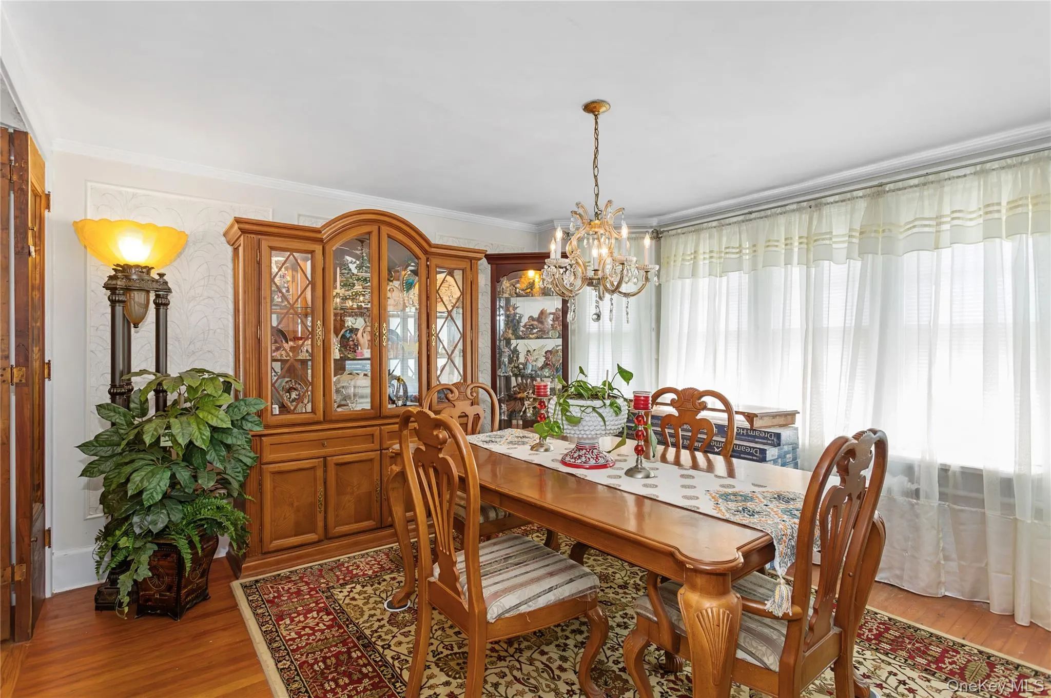 Dining room featuring a chandelier, light wood-style floors, and crown molding Dining room featuring a chandelier, light wood-style floors, and crown molding