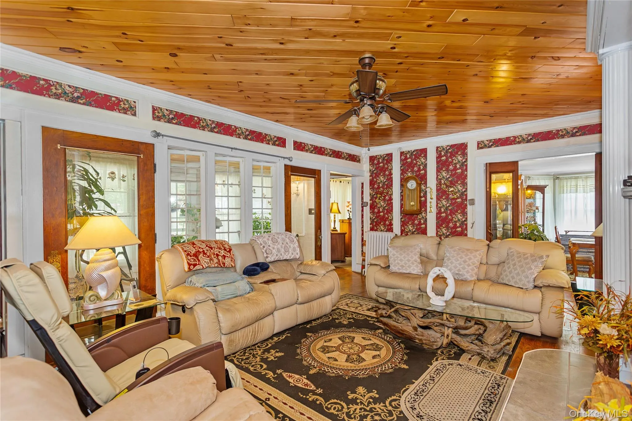 Living area with crown molding, wooden ceiling, wood finished floors, and ceiling fan Living area with crown molding, wooden ceiling, wood finished floors, and ceiling fan