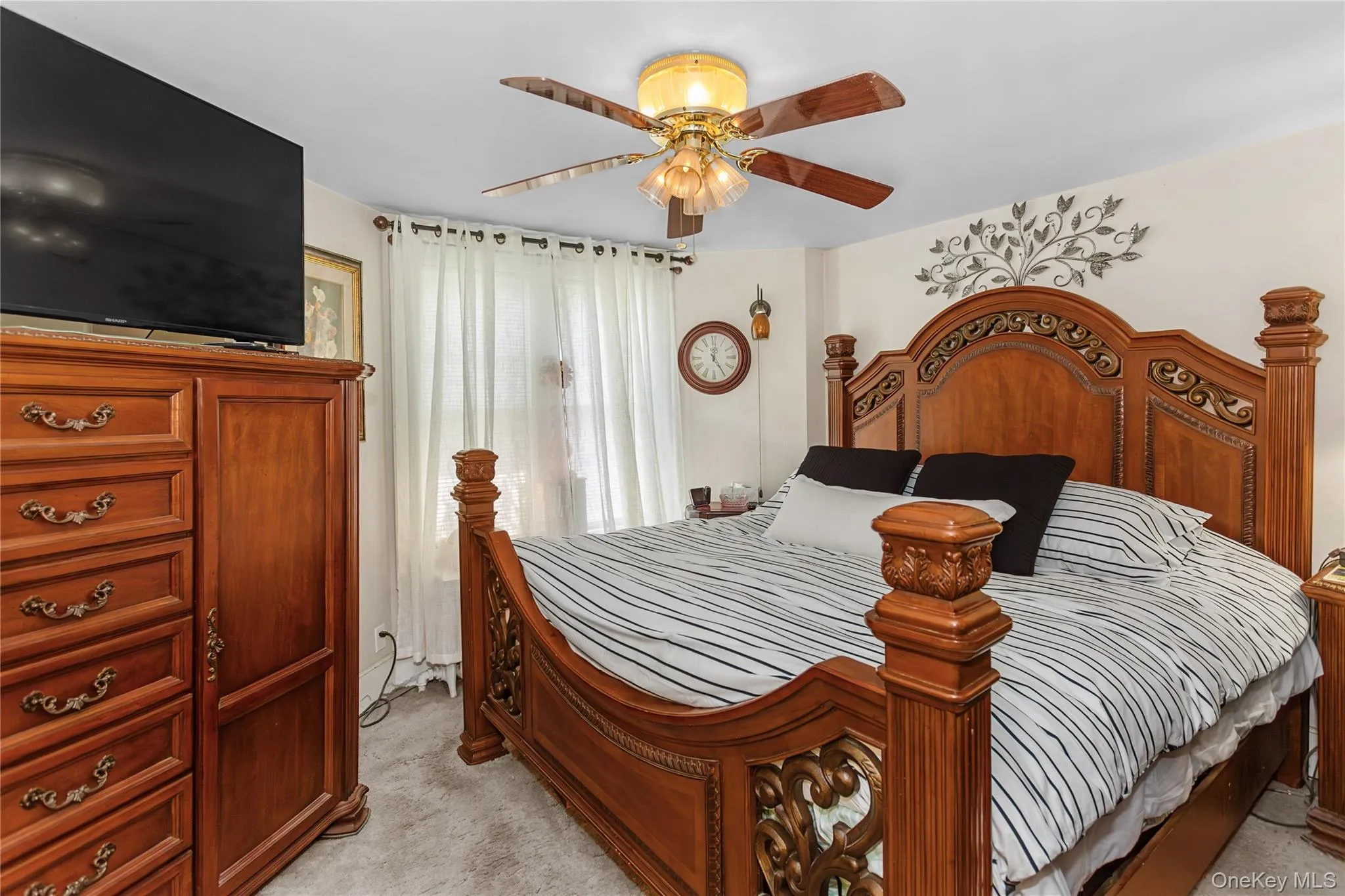 Bedroom featuring light carpet and a ceiling fan Bedroom featuring light carpet and a ceiling fan