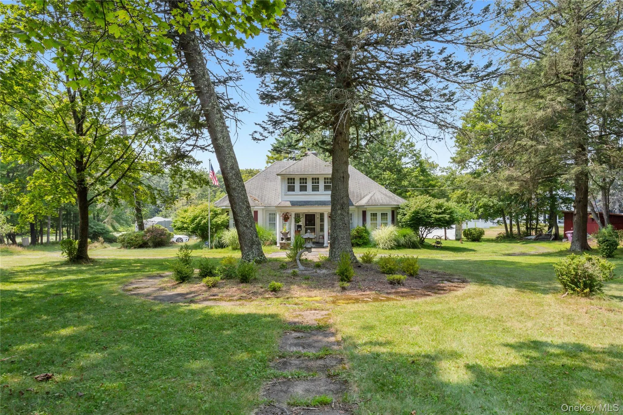 View of front of home with a front lawn and a shingled roof View of front of home with a front lawn and a shingled roof