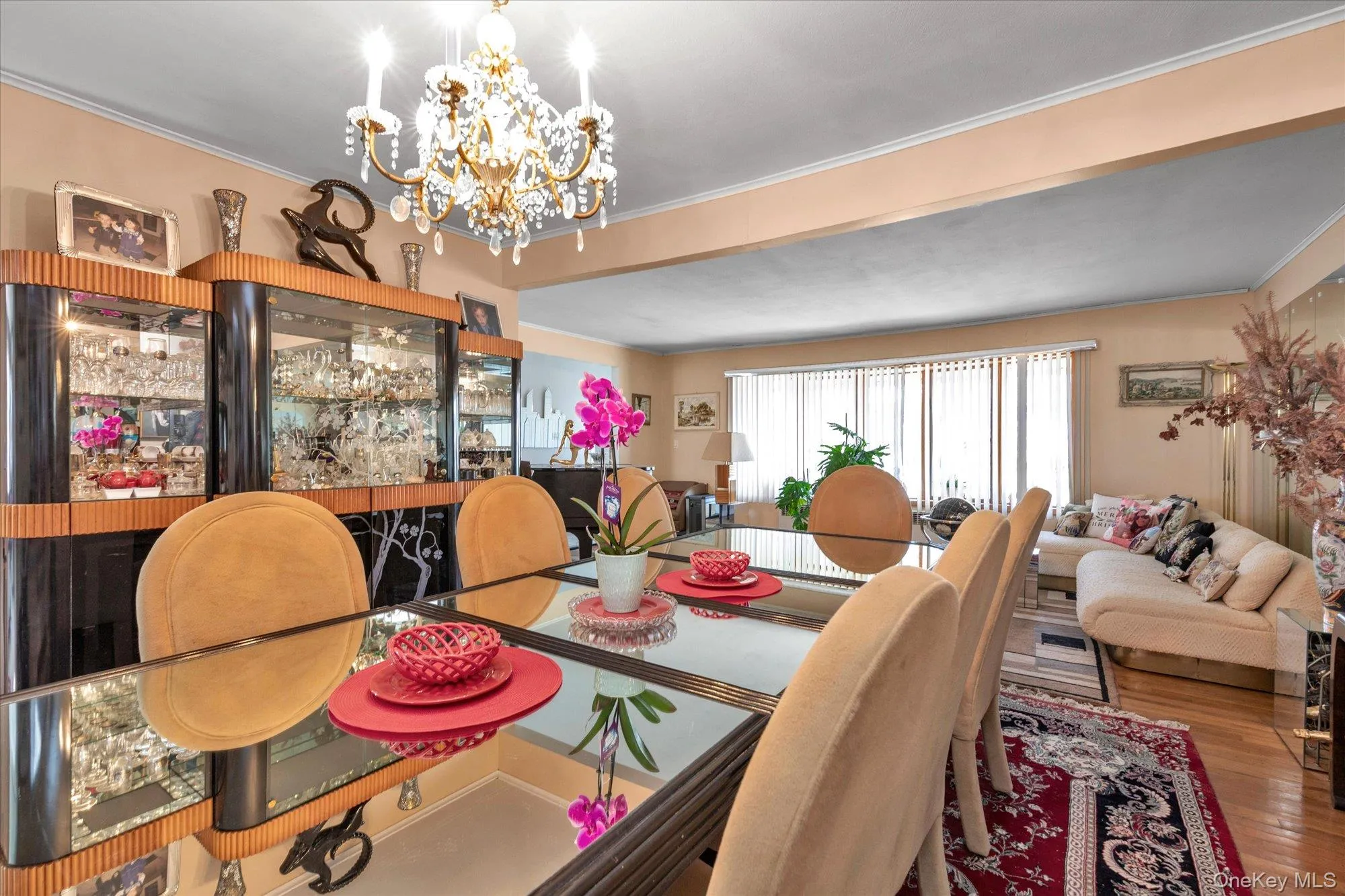 Dining area featuring a mirrored table, chandelier lighting, wood-finish flooring, built-in display cabinetry Dining area featuring a mirrored table, chandelier lighting, wood-finish flooring, built-in display cabinetry