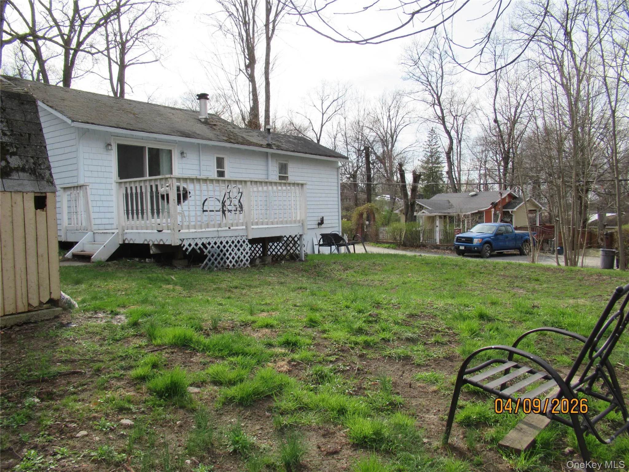 The property features a white exterior with a deck, complete with white railings and lattice skirting The property features a white exterior with a deck, complete with white railings and lattice skirting