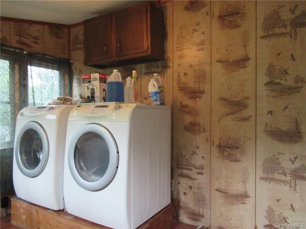 Clothes washing area with washer and clothes dryer and cabinets Clothes washing area with washer and clothes dryer and cabinets