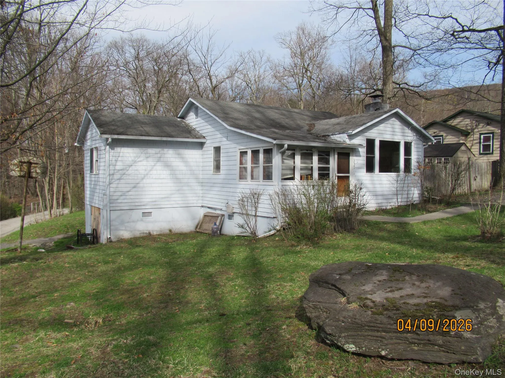 The property features a white exterior, a well-maintained lawn, and established trees The property features a white exterior, a well-maintained lawn, and established trees