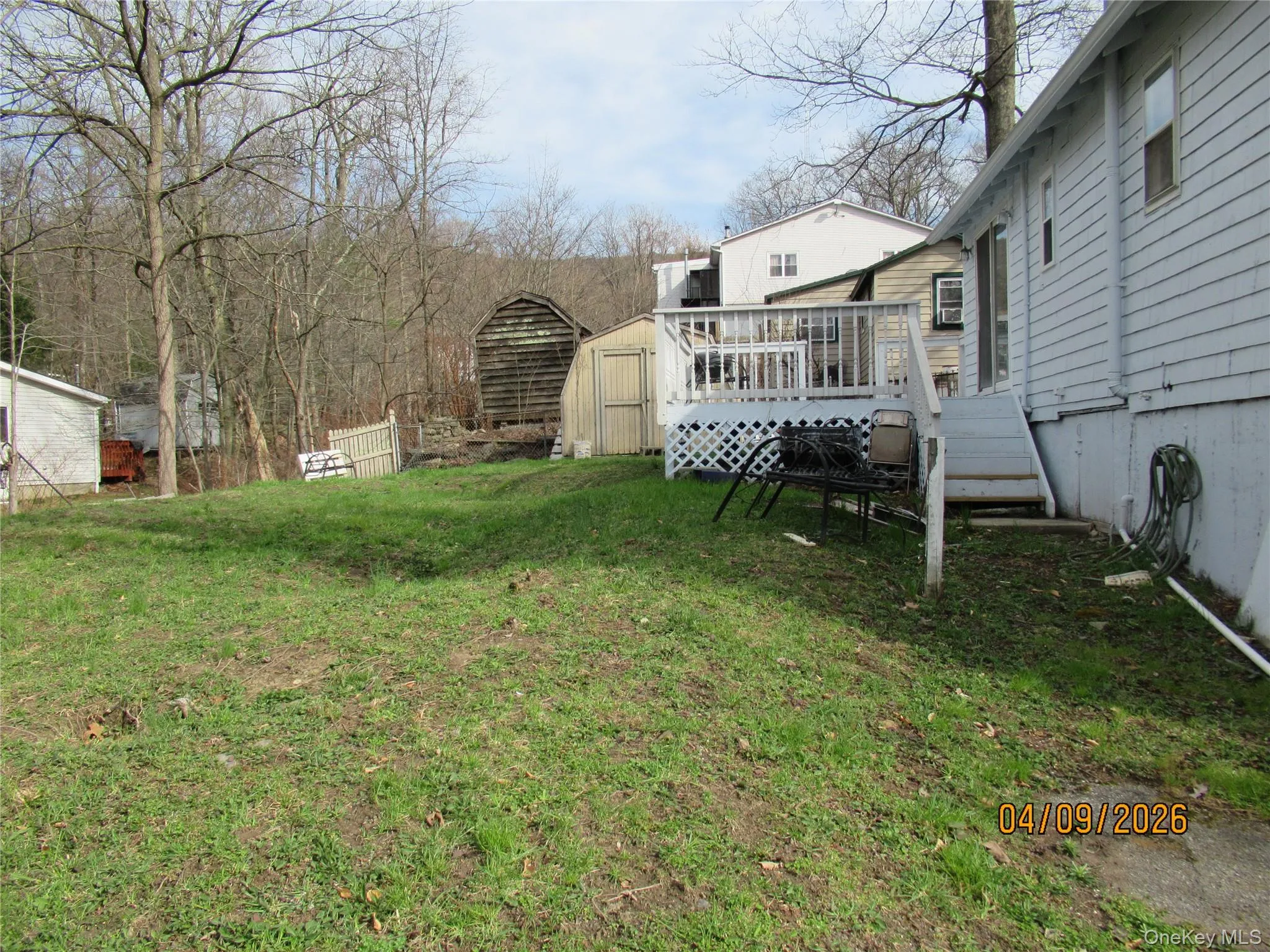 The property features an extensive lawn area and a wooden deck with railing The property features an extensive lawn area and a wooden deck with railing