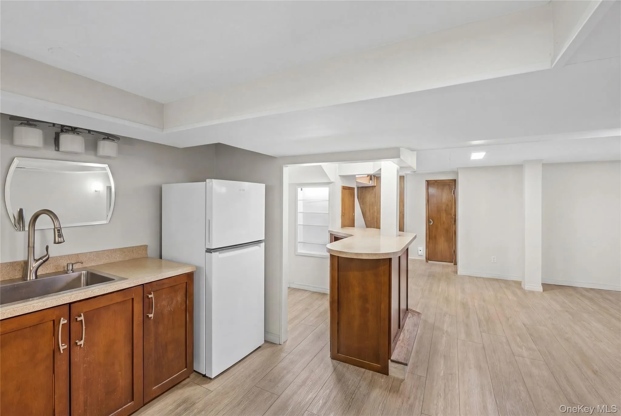This expansive space features light wood-look flooring, a wet bar with a curved countertop. This expansive space features light wood-look flooring, a wet bar with a curved countertop.