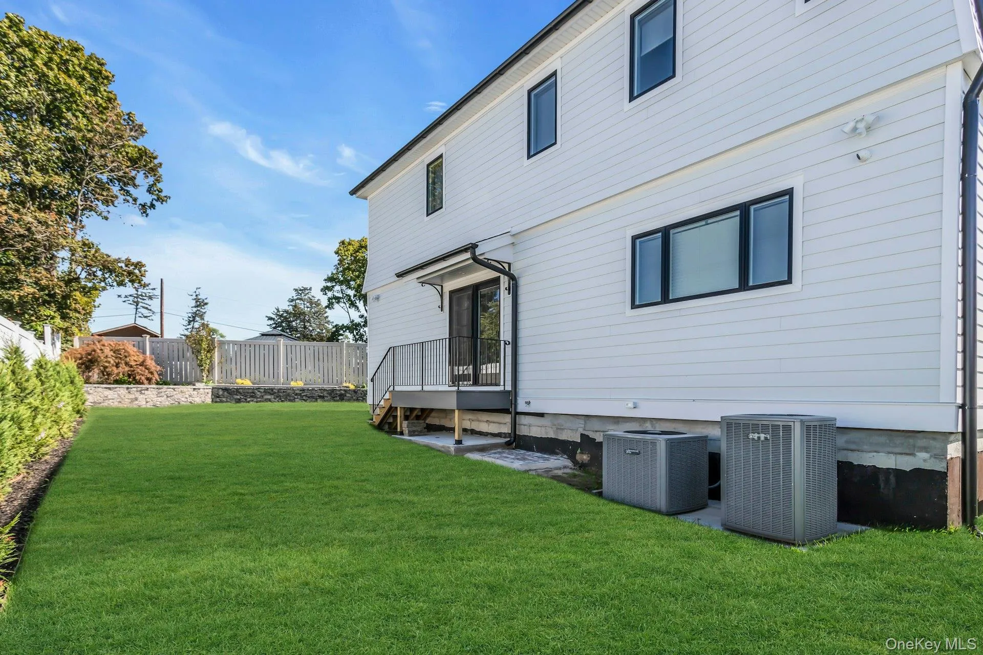 The property features a well-maintained lawn and a private deck with railings The property features a well-maintained lawn and a private deck with railings