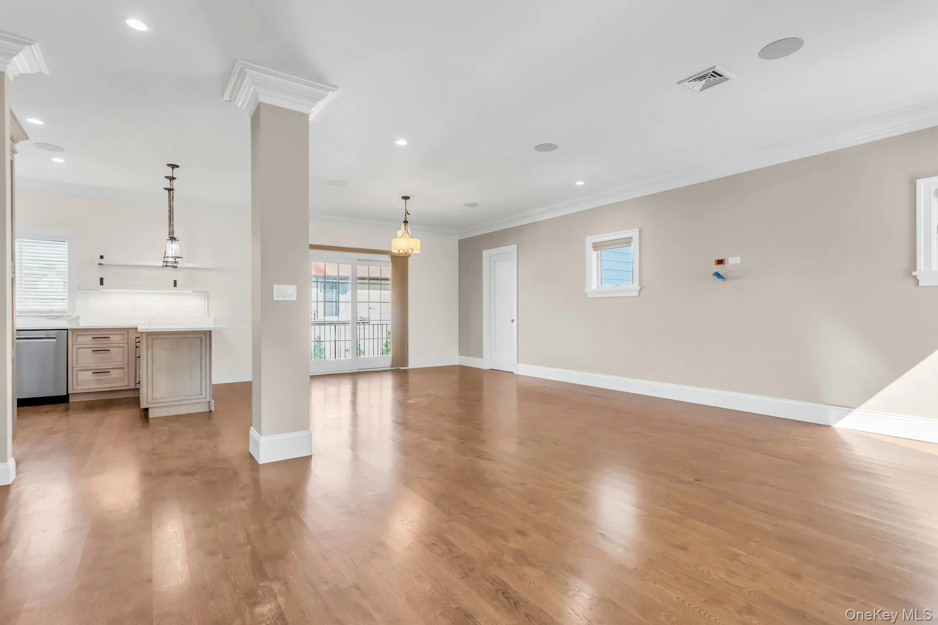 Open-concept living area featuring hardwood flooring, recessed lighting, and crown molding Open-concept living area featuring hardwood flooring, recessed lighting, and crown molding