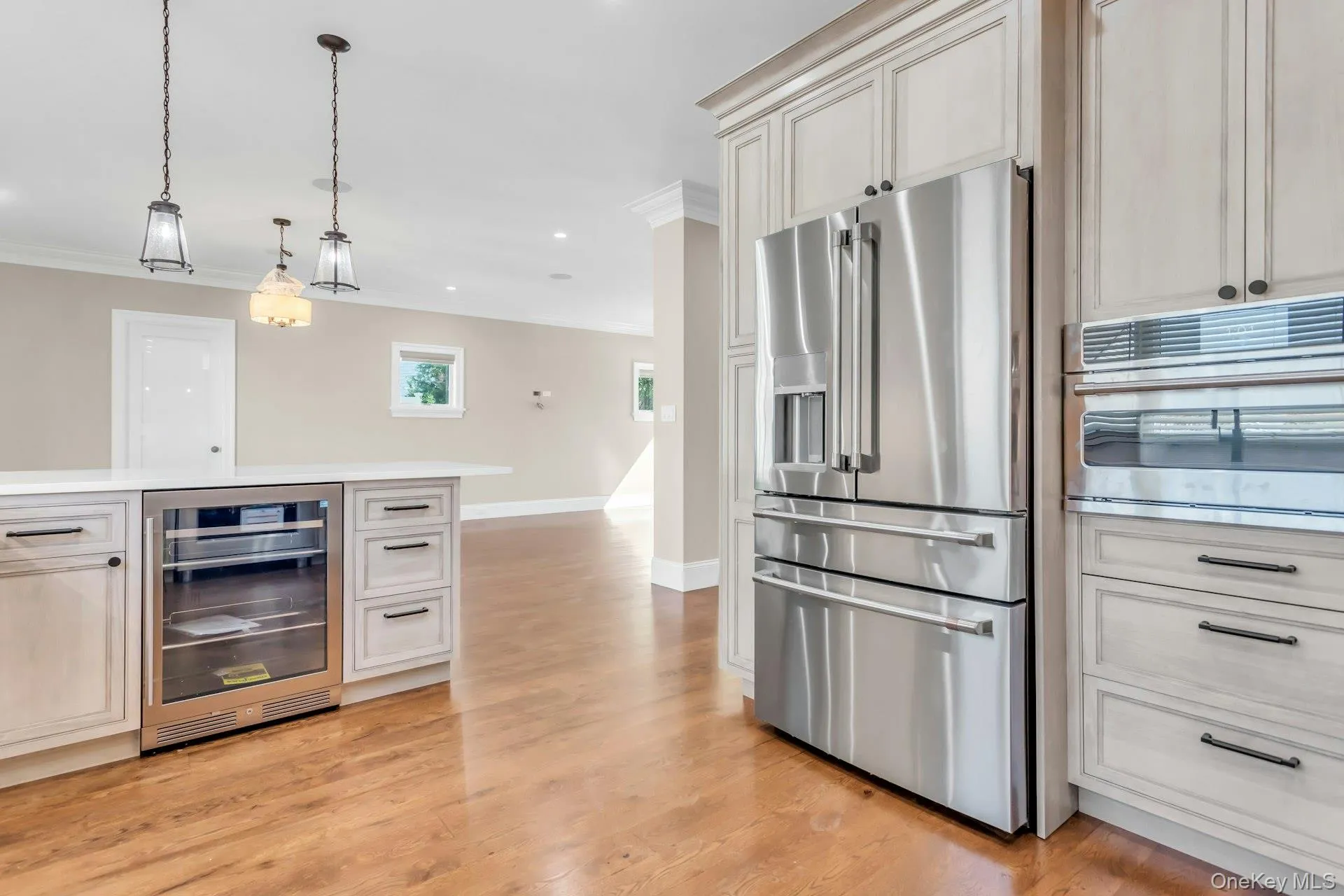 This kitchen features stainless steel appliances, including a French door refrigerator, a built-in oven, and a beverage cooler This kitchen features stainless steel appliances, including a French door refrigerator, a built-in oven, and a beverage cooler