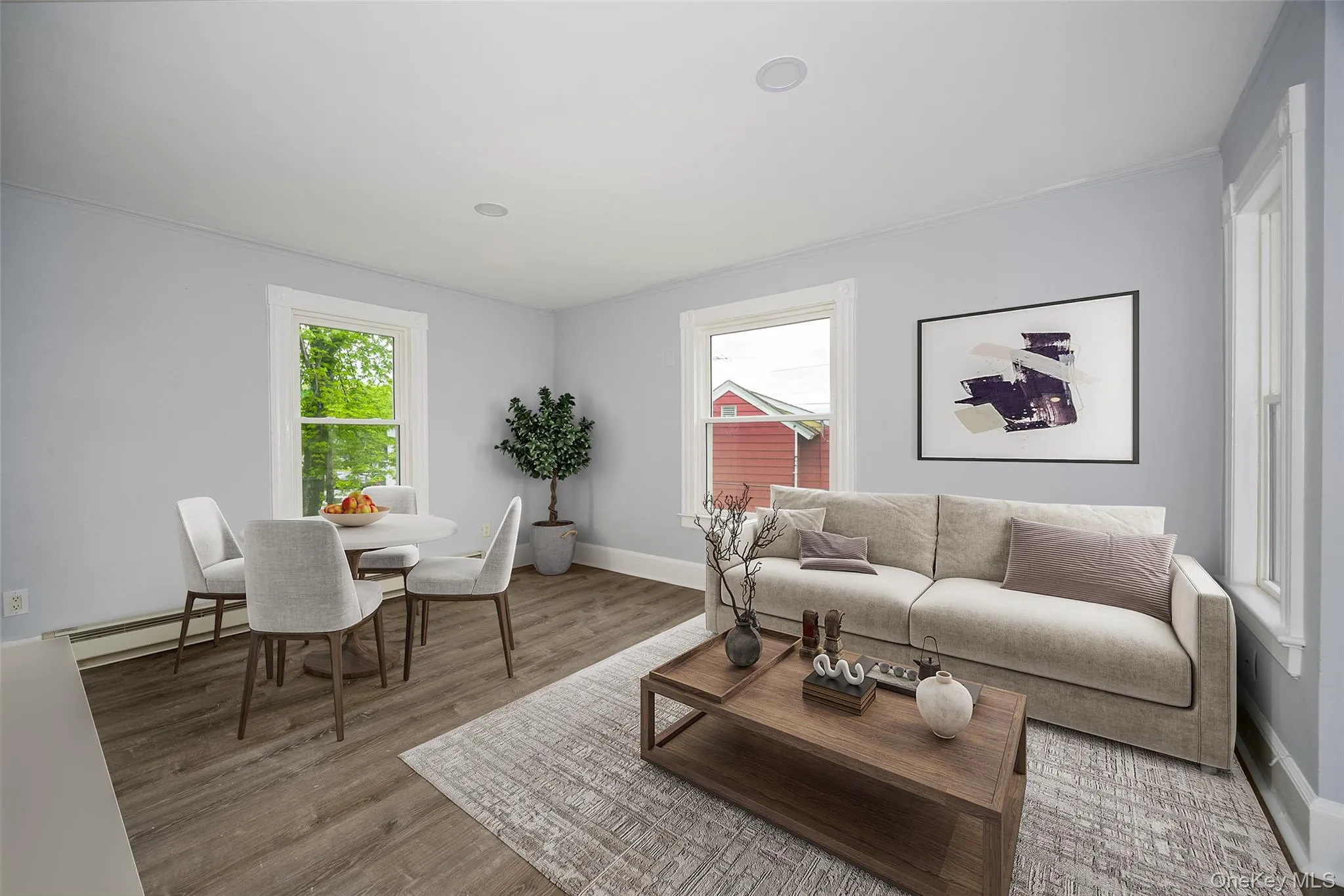 Open-concept living area with wood-finish flooring, recessed lighting, and white window trim Open-concept living area with wood-finish flooring, recessed lighting, and white window trim
