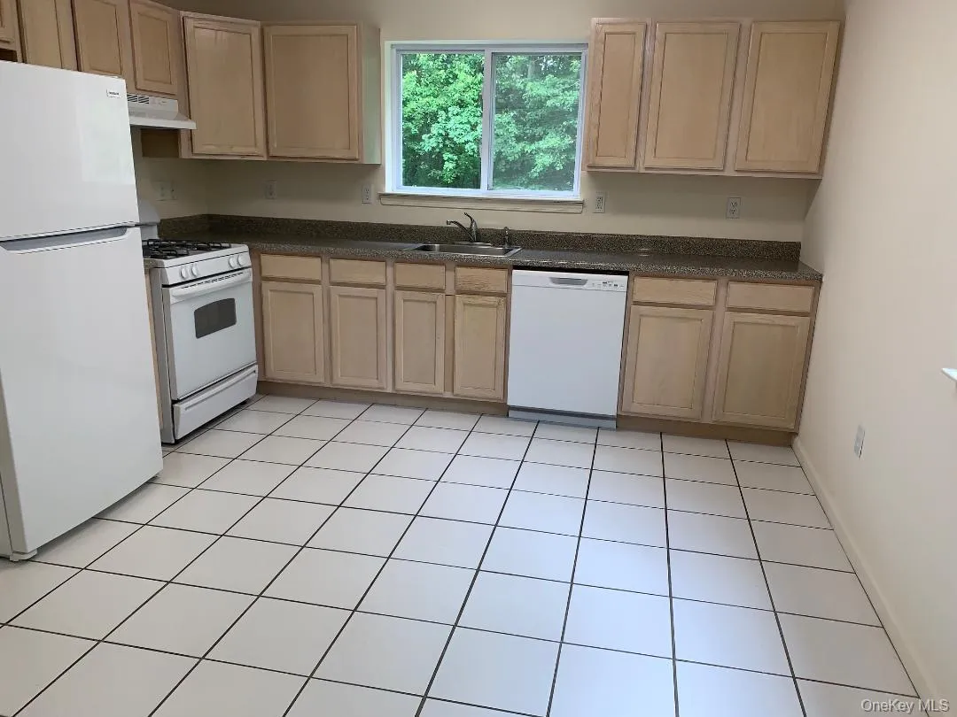 The large eat in kitchen has maple cabinets, a refrigerator, gas range, dishwasher and a pantry. There's a pretty wooded view from kitchen window. The large eat in kitchen has maple cabinets, a refrigerator, gas range, dishwasher and a pantry. There's a pretty wooded view from kitchen window.