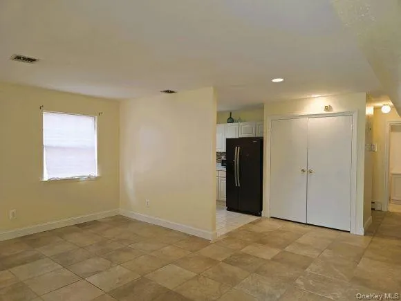 Livingroom/ dining room combo featuring neutral tone tiled flooring, light-colored walls, and windows with blinds Livingroom/ dining room combo featuring neutral tone tiled flooring, light-colored walls, and windows with blinds