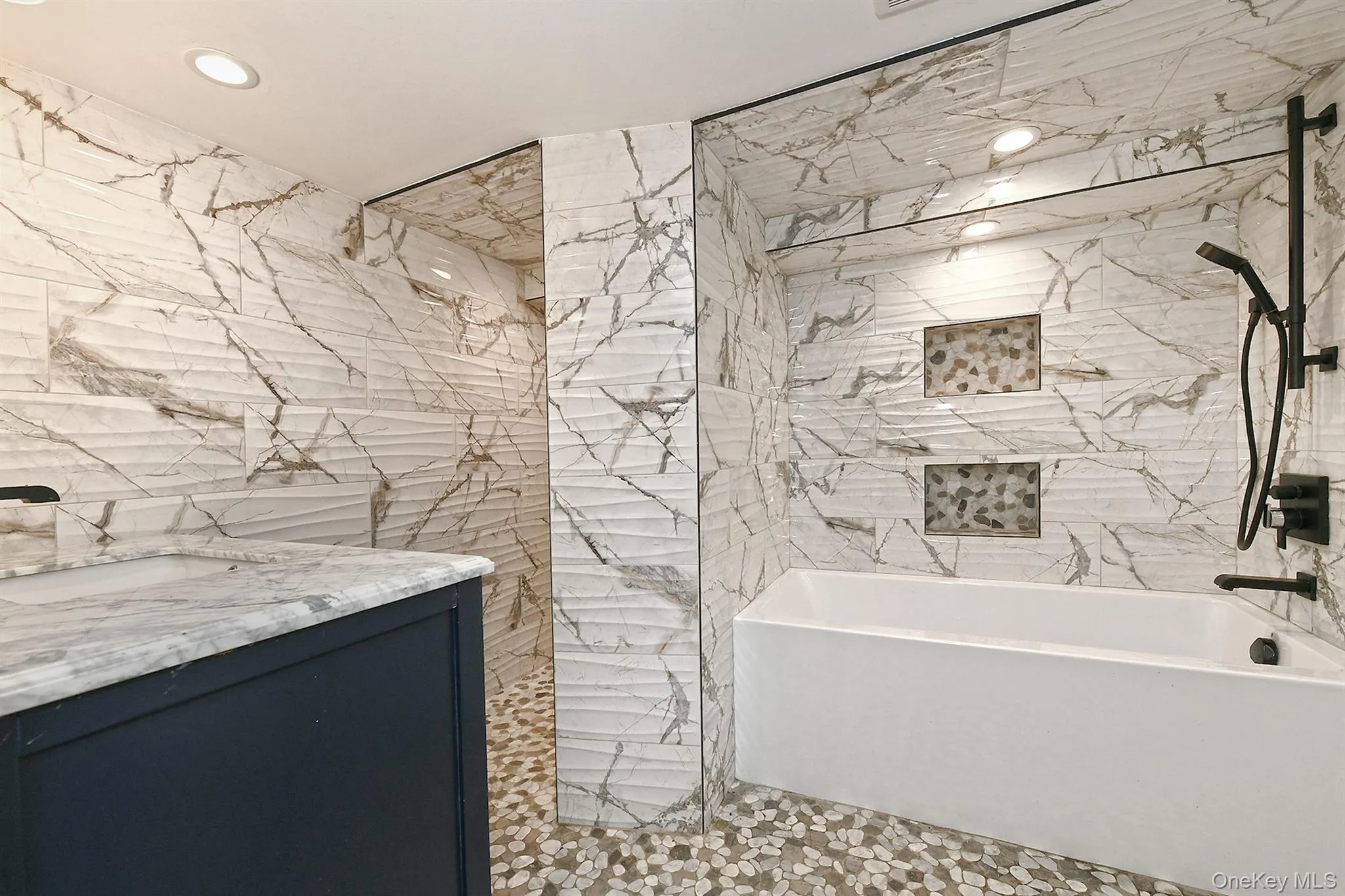 Full bathroom with recessed lighting, tile walls, shower and bathtub Full bathroom with recessed lighting, tile walls, shower and bathtub