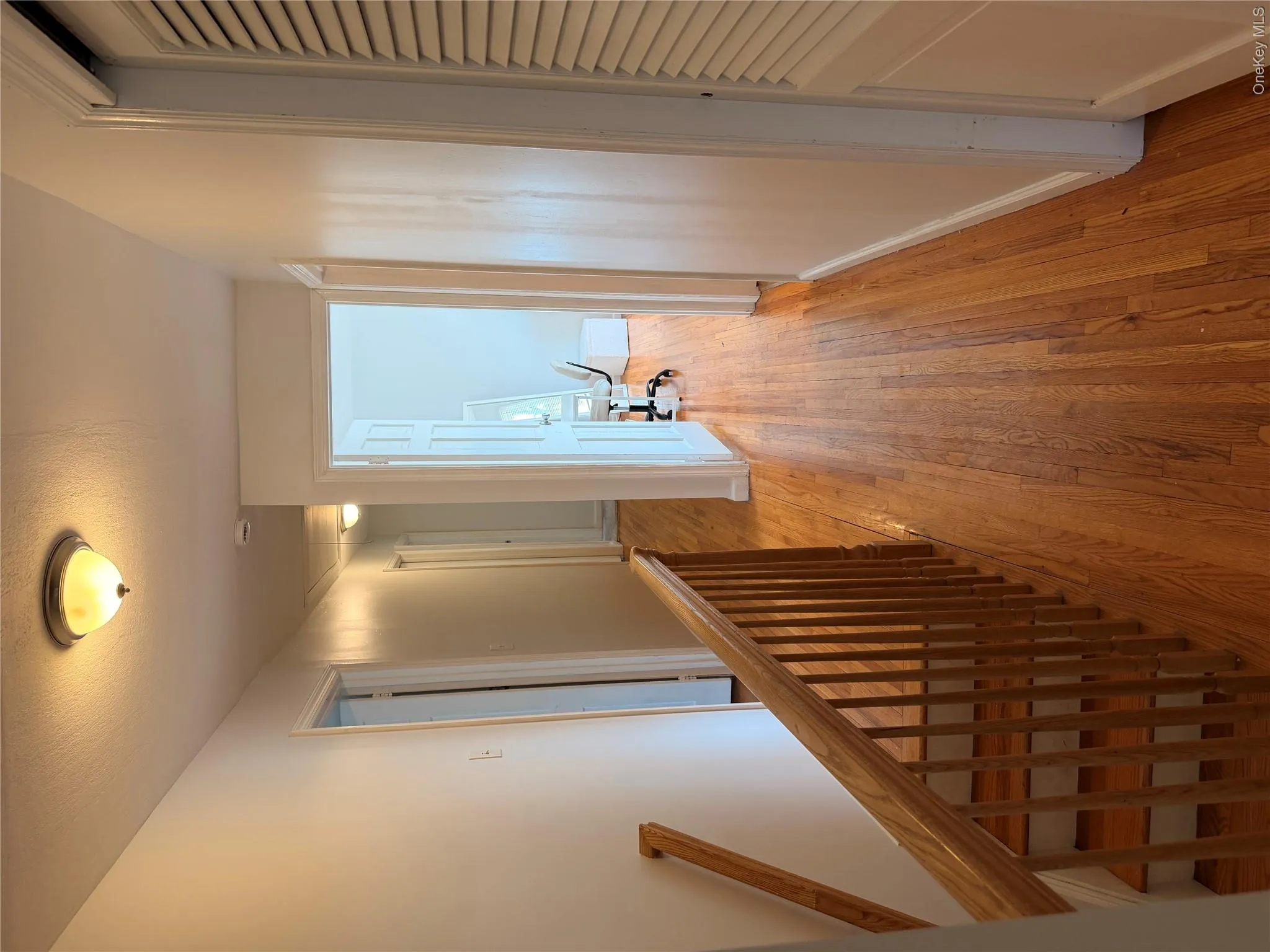 The property features hardwood flooring throughout the hallway and a wooden staircase with a matching railing The property features hardwood flooring throughout the hallway and a wooden staircase with a matching railing