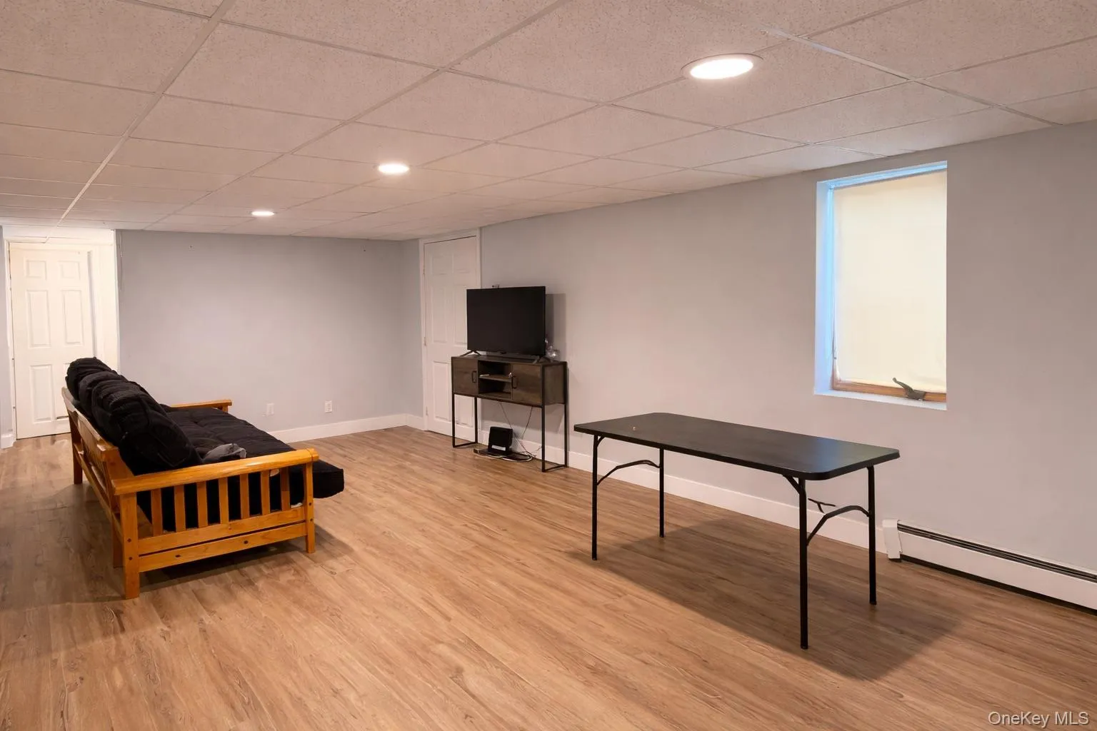 This spacious room features light wood-style flooring, light-colored walls, and recessed lighting in the ceiling This spacious room features light wood-style flooring, light-colored walls, and recessed lighting in the ceiling