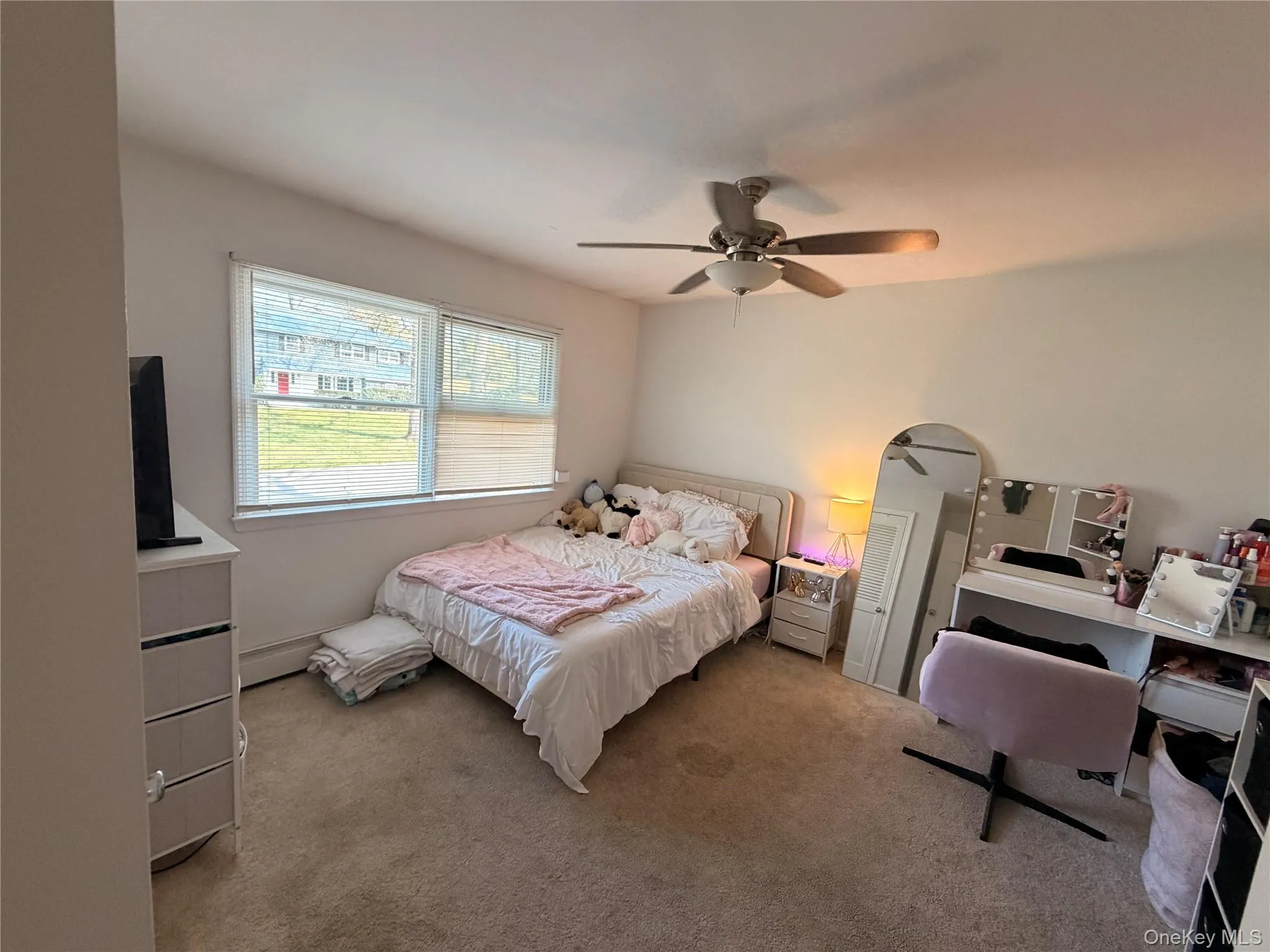 The room features a carpeted floor, white walls, and a ceiling fan with a light fixture The room features a carpeted floor, white walls, and a ceiling fan with a light fixture