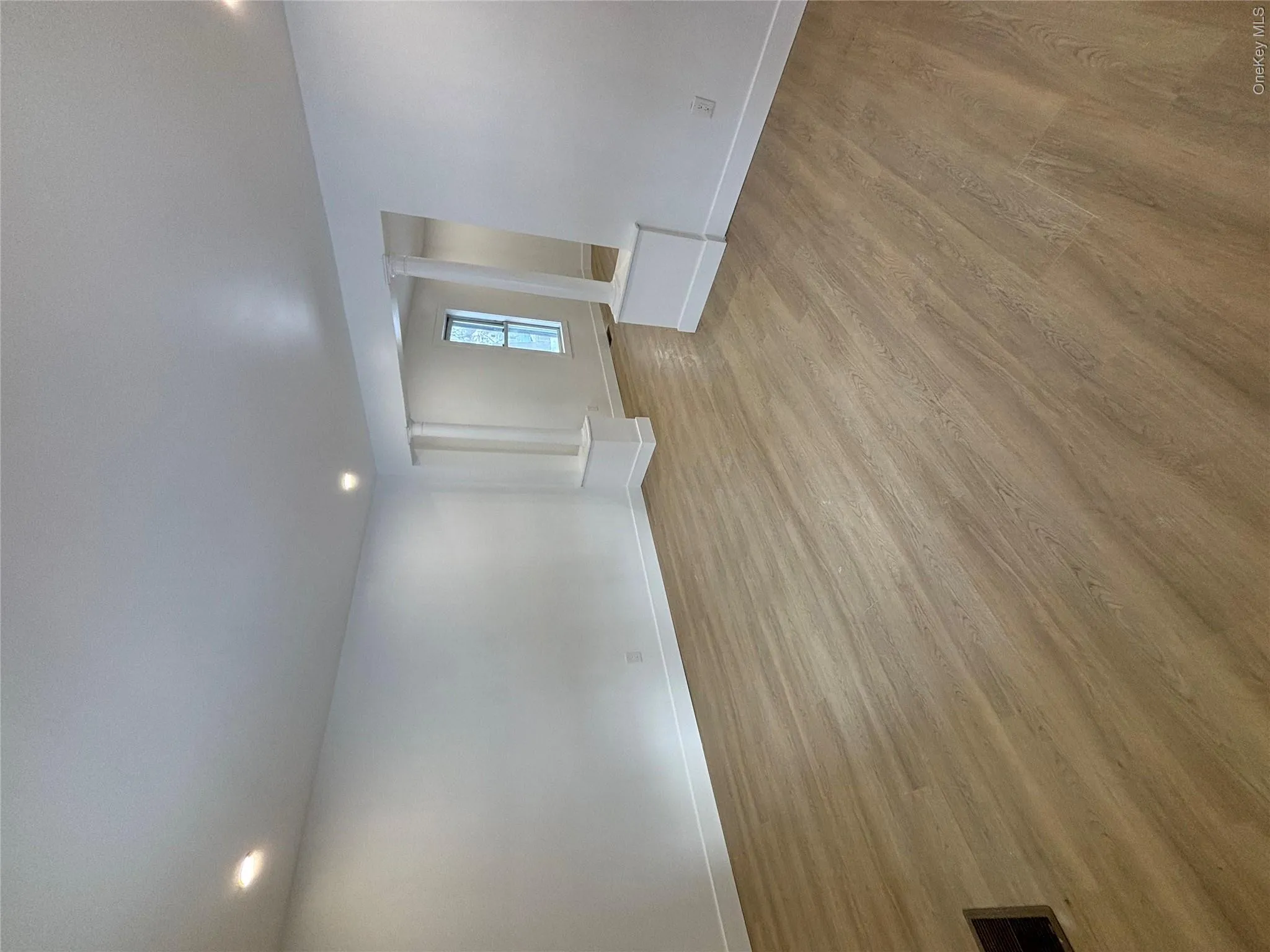 Spare room with light wood finished floors, decorative columns, and recessed lighting Spare room with light wood finished floors, decorative columns, and recessed lighting