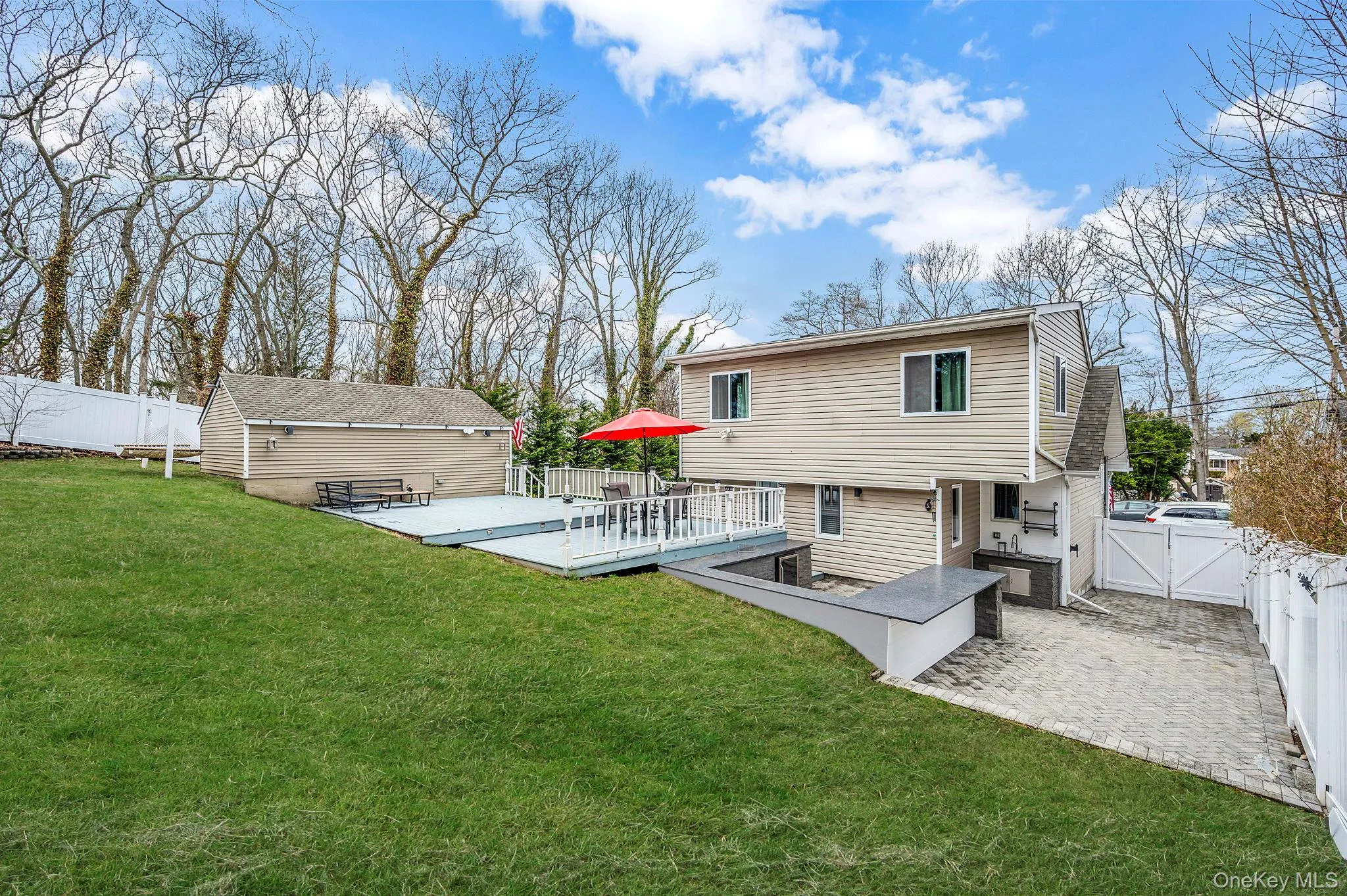 The property features a spacious yard with a lush lawn, a multi-level deck, and a detached shed The property features a spacious yard with a lush lawn, a multi-level deck, and a detached shed