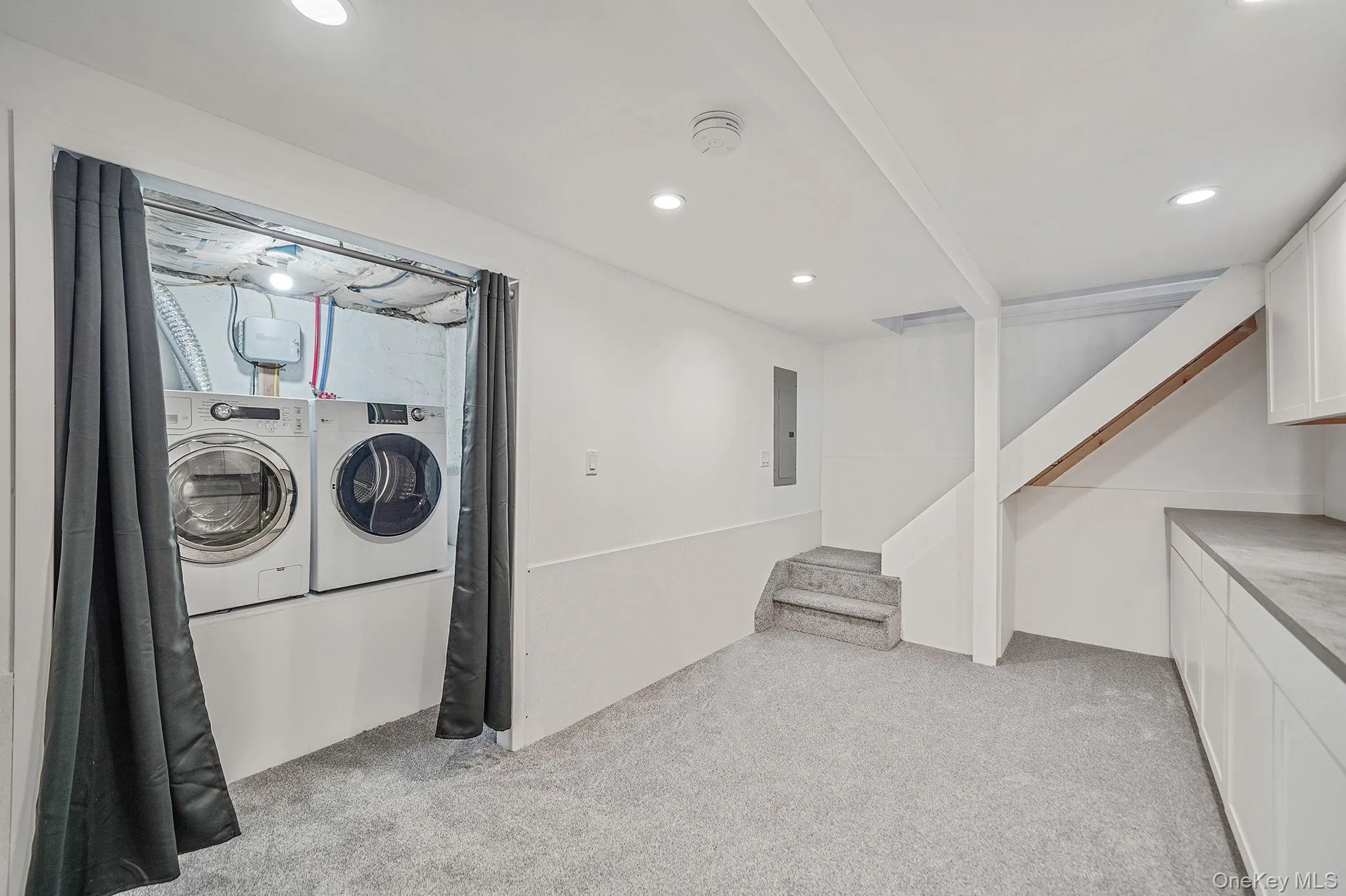 Laundry area featuring a washing machine and a dryer, with nearby built-in cabinetry and countertop space Laundry area featuring a washing machine and a dryer, with nearby built-in cabinetry and countertop space