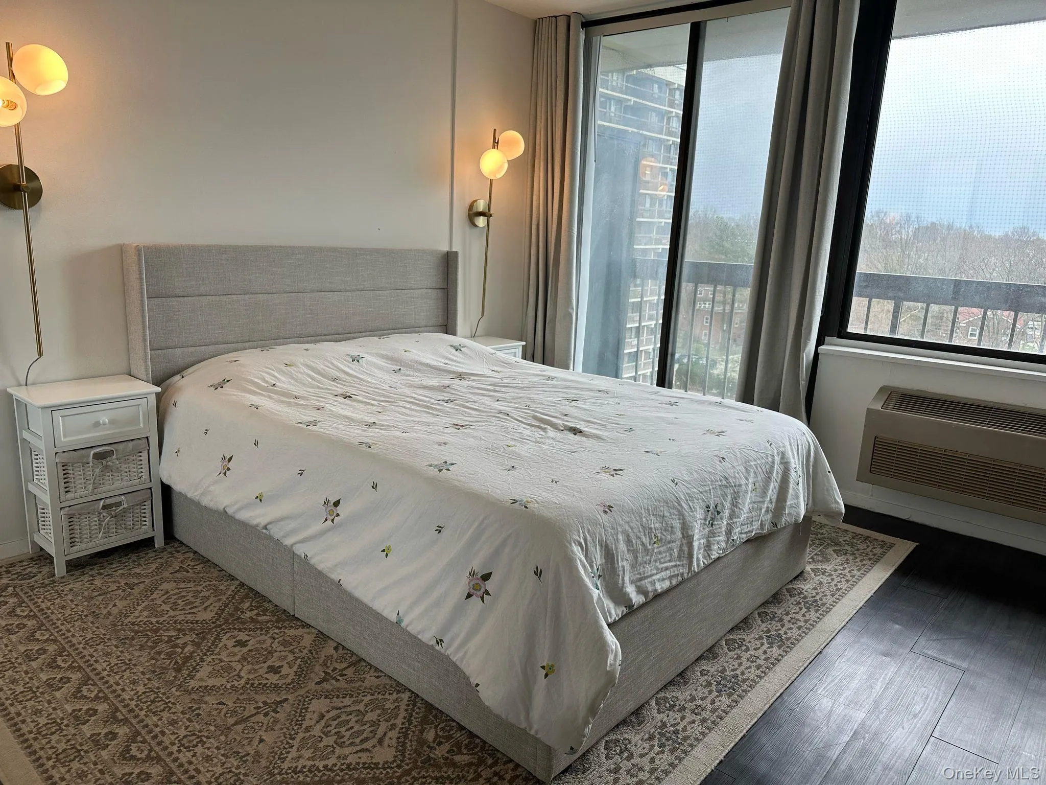 Bedroom with access to outside, wood finished floors, and an AC wall unit Bedroom with access to outside, wood finished floors, and an AC wall unit