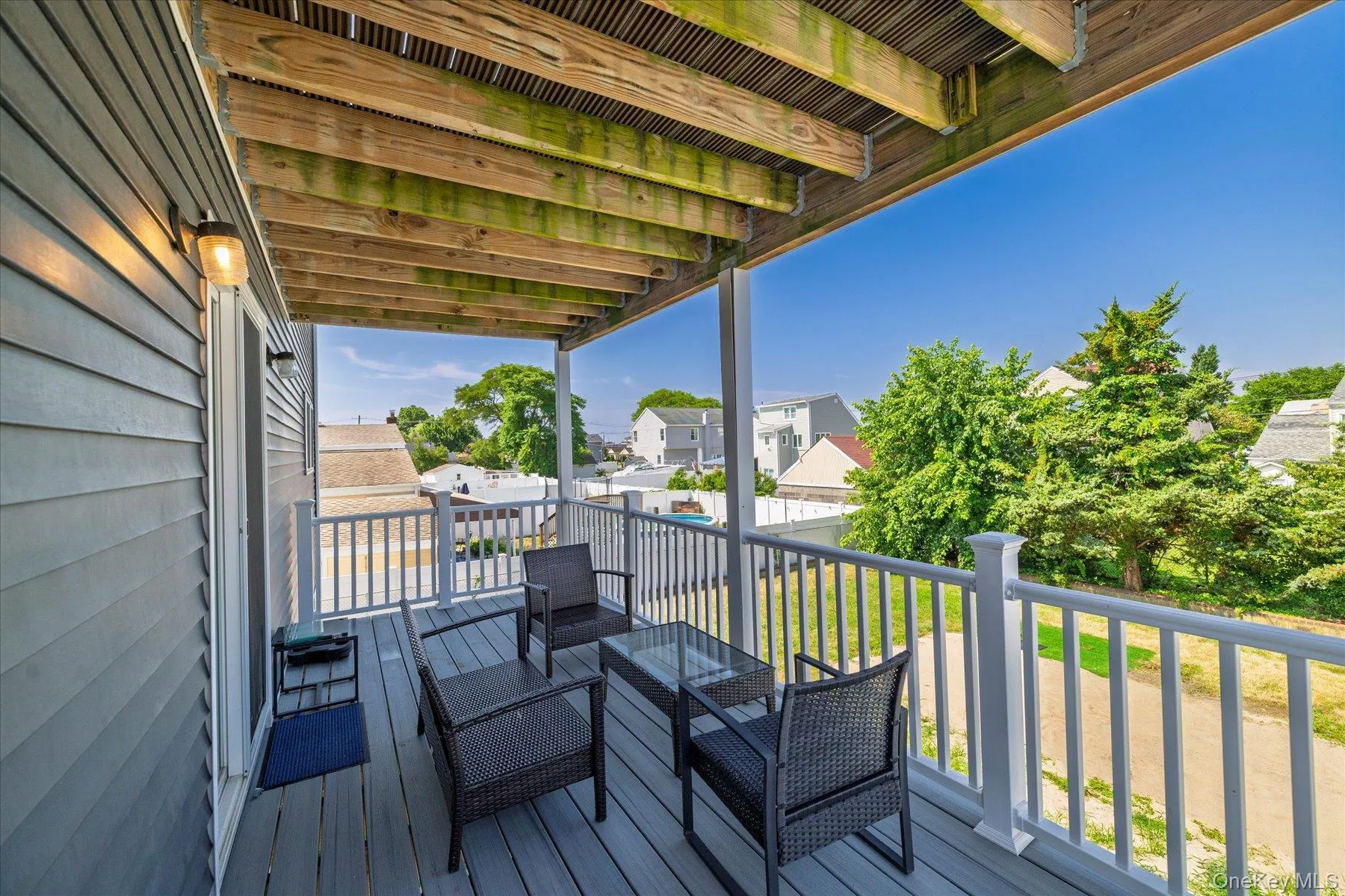 Covered outdoor deck with grey composite decking and white railings Covered outdoor deck with grey composite decking and white railings