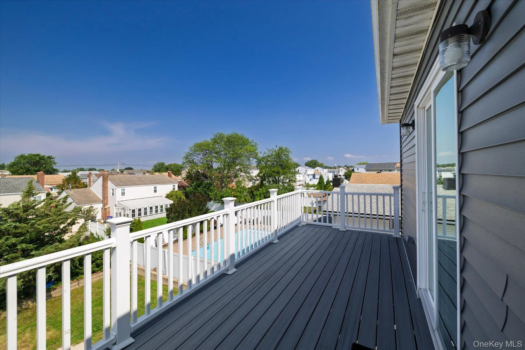Outdoor deck featuring composite decking and white railing system Outdoor deck featuring composite decking and white railing system