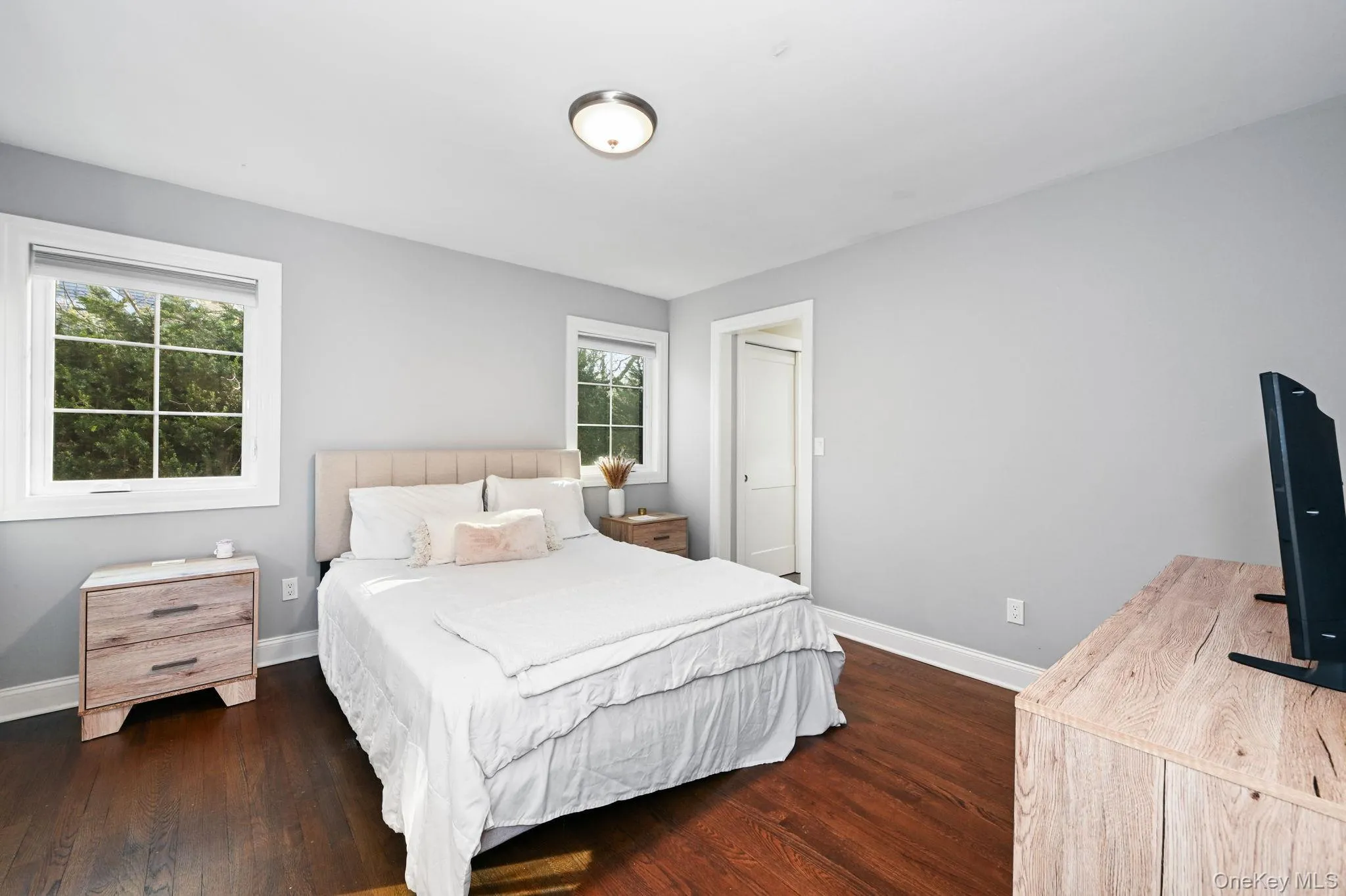 The owner’s suite is adorned with two large windows and hardwood flooring, and features a hallway leading to a private bathroom and closet. The owner’s suite is adorned with two large windows and hardwood flooring, and features a hallway leading to a private bathroom and closet.