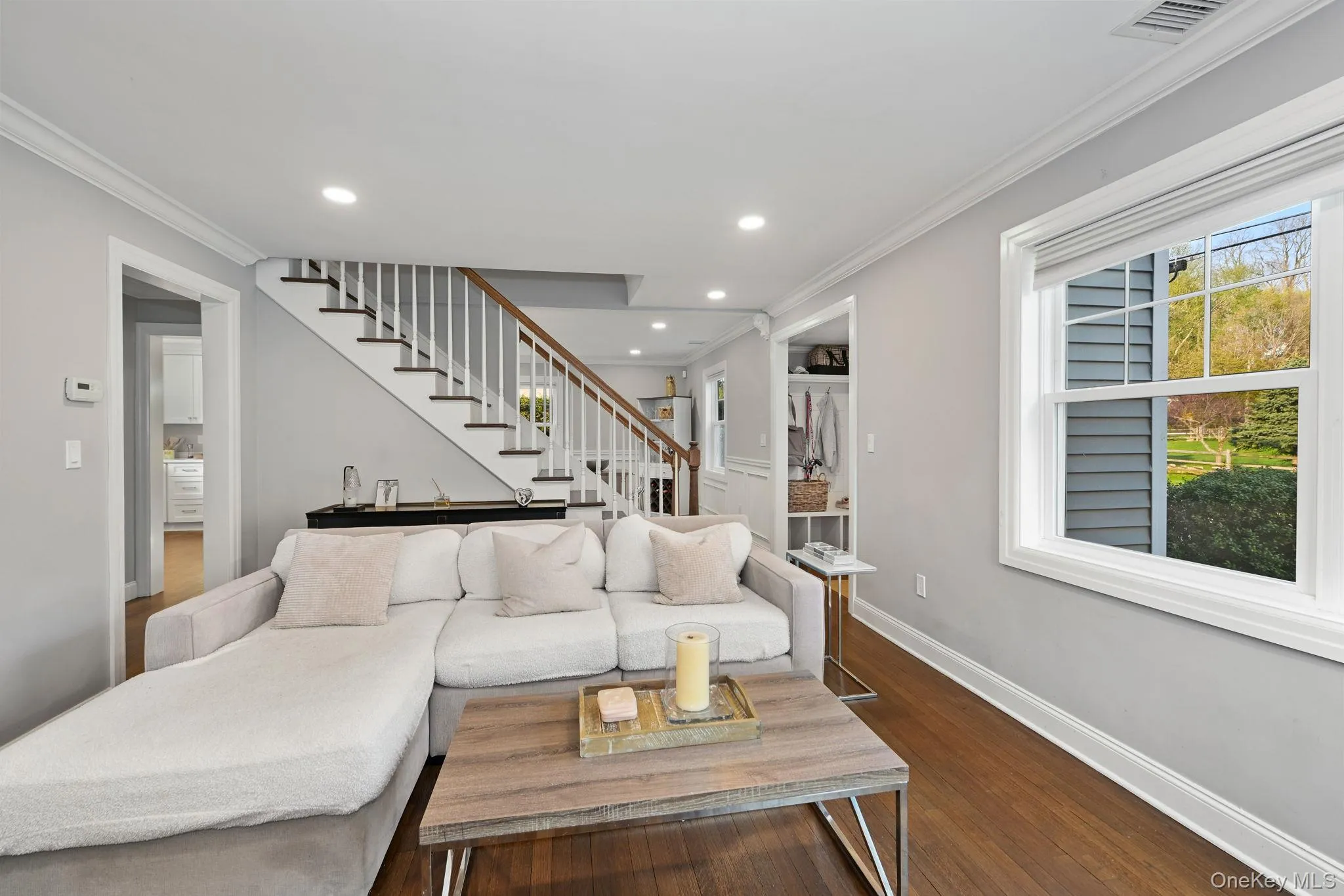 The living room is enhanced by large windows, recessed lighting, and hardwood flooring, creating a bright and inviting space. The living room is enhanced by large windows, recessed lighting, and hardwood flooring, creating a bright and inviting space.